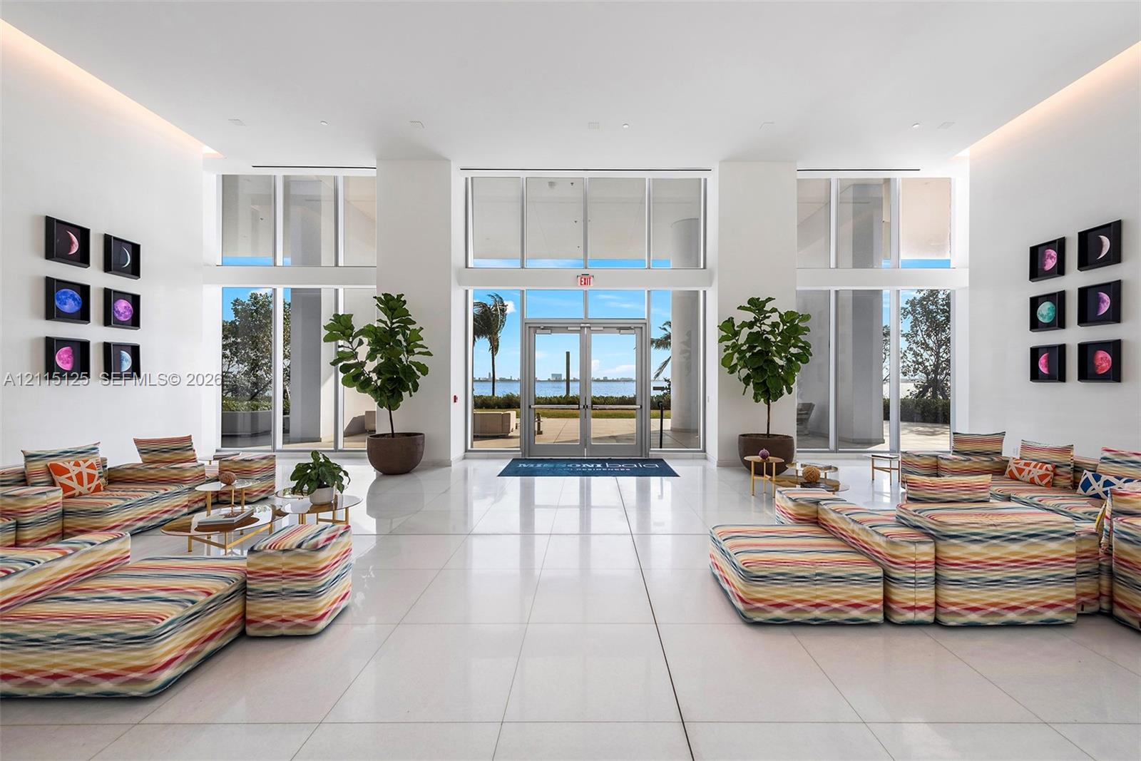 Grand lobby featuring high ceilings, expansive floor-to-ceiling windows, polished stone-finish flooring, and recessed cove lighting
