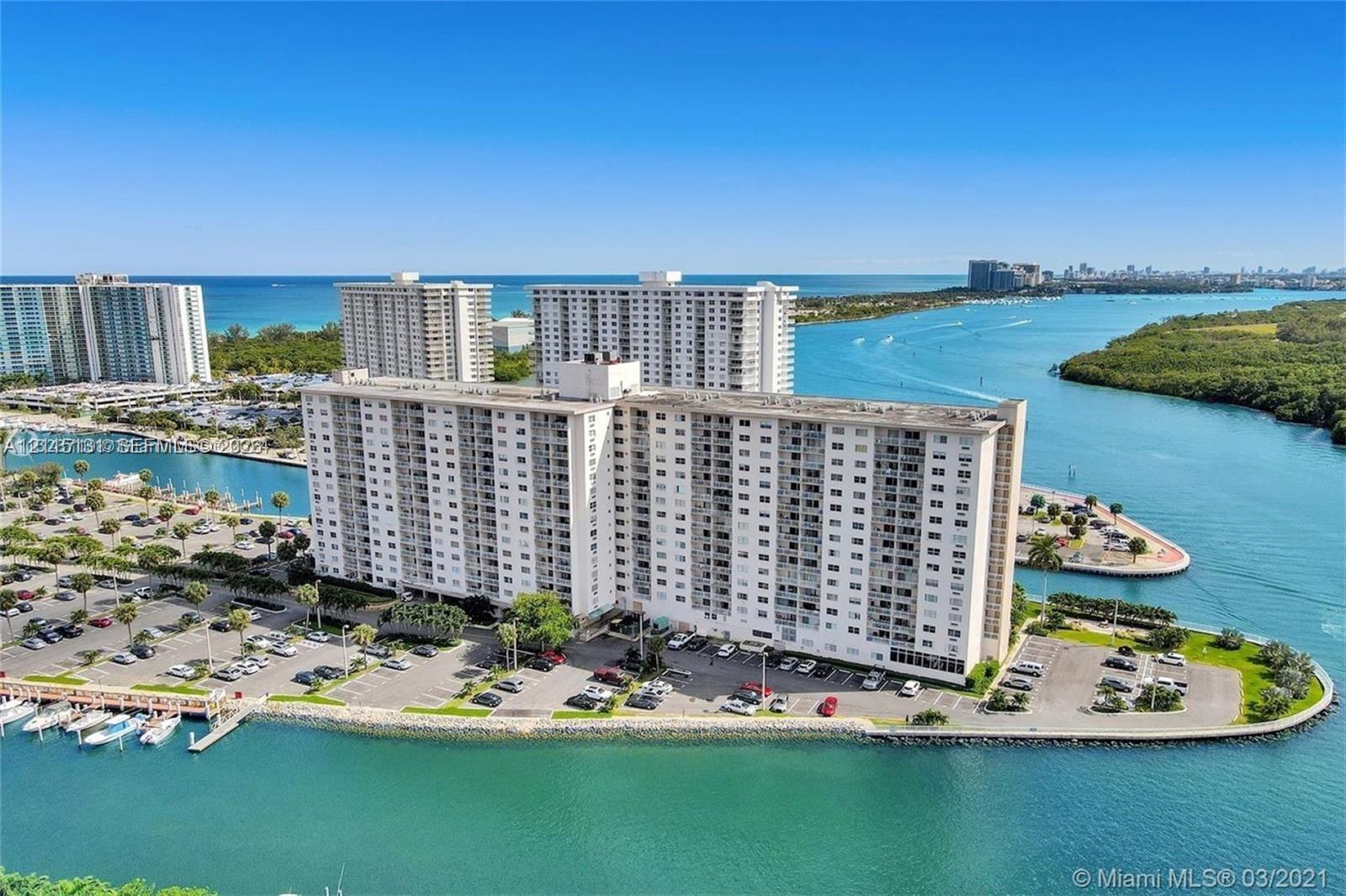 High-rise residential building situated on a peninsula with expansive water frontage, boat docks, and surface parking High-rise residential building situated on a peninsula with expansive water frontage, boat docks, and surface parking