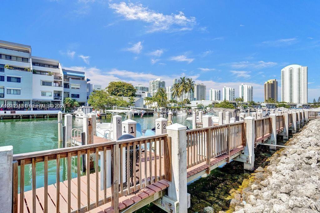 Waterfront boat dock featuring individual slip numbering, wooden decking, and a protective railing Waterfront boat dock featuring individual slip numbering, wooden decking, and a protective railing