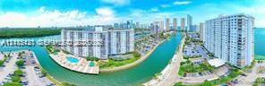 Aerial perspective featuring waterfront residential buildings, a paved swimming pool deck, canal access, and surface parking areas Aerial perspective featuring waterfront residential buildings, a paved swimming pool deck, canal access, and surface parking areas