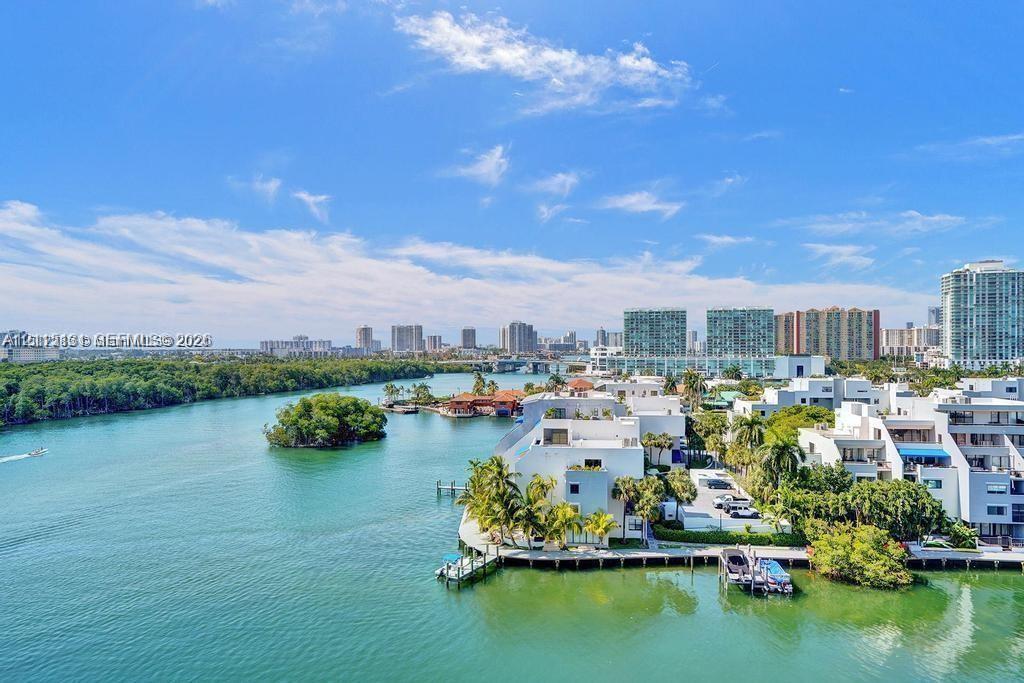 Waterfront property featuring a private boat dock, concrete seawall, and extensive exterior balconies Waterfront property featuring a private boat dock, concrete seawall, and extensive exterior balconies
