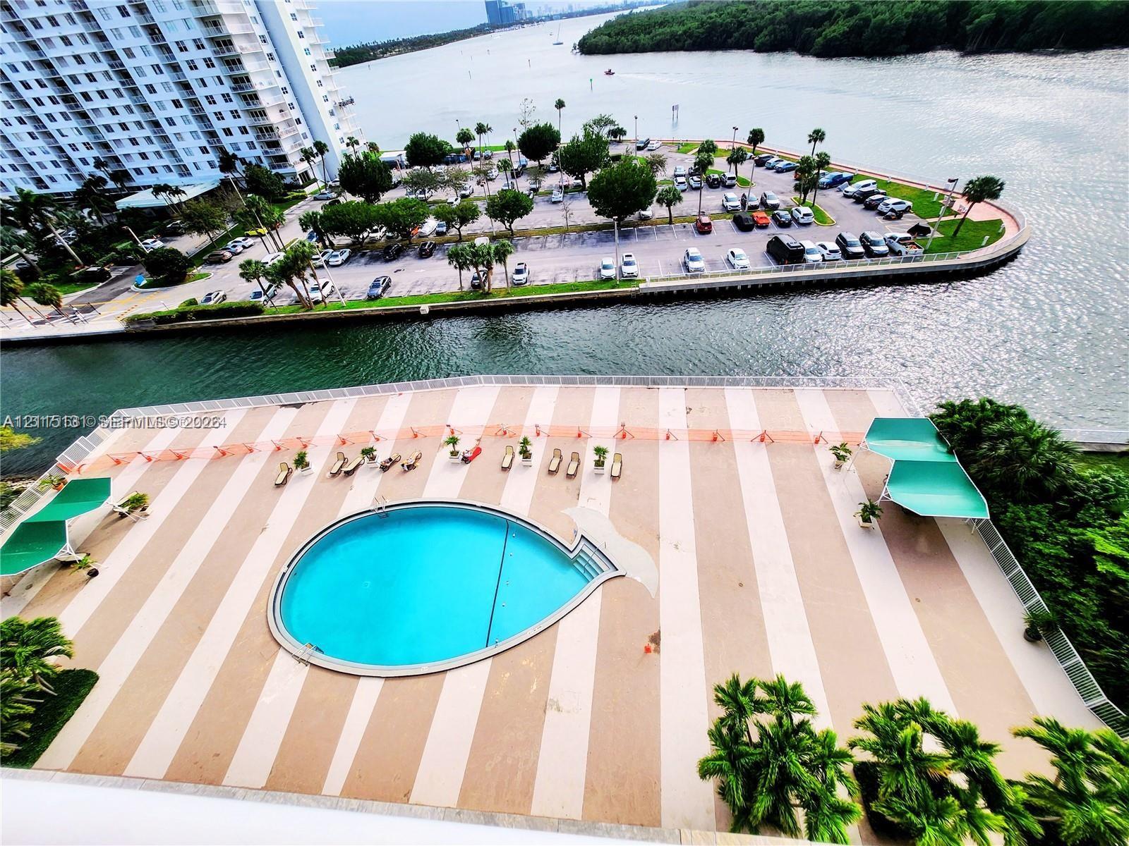 Outdoor pool deck featuring a circular swimming pool, paved surface, and two shaded structures