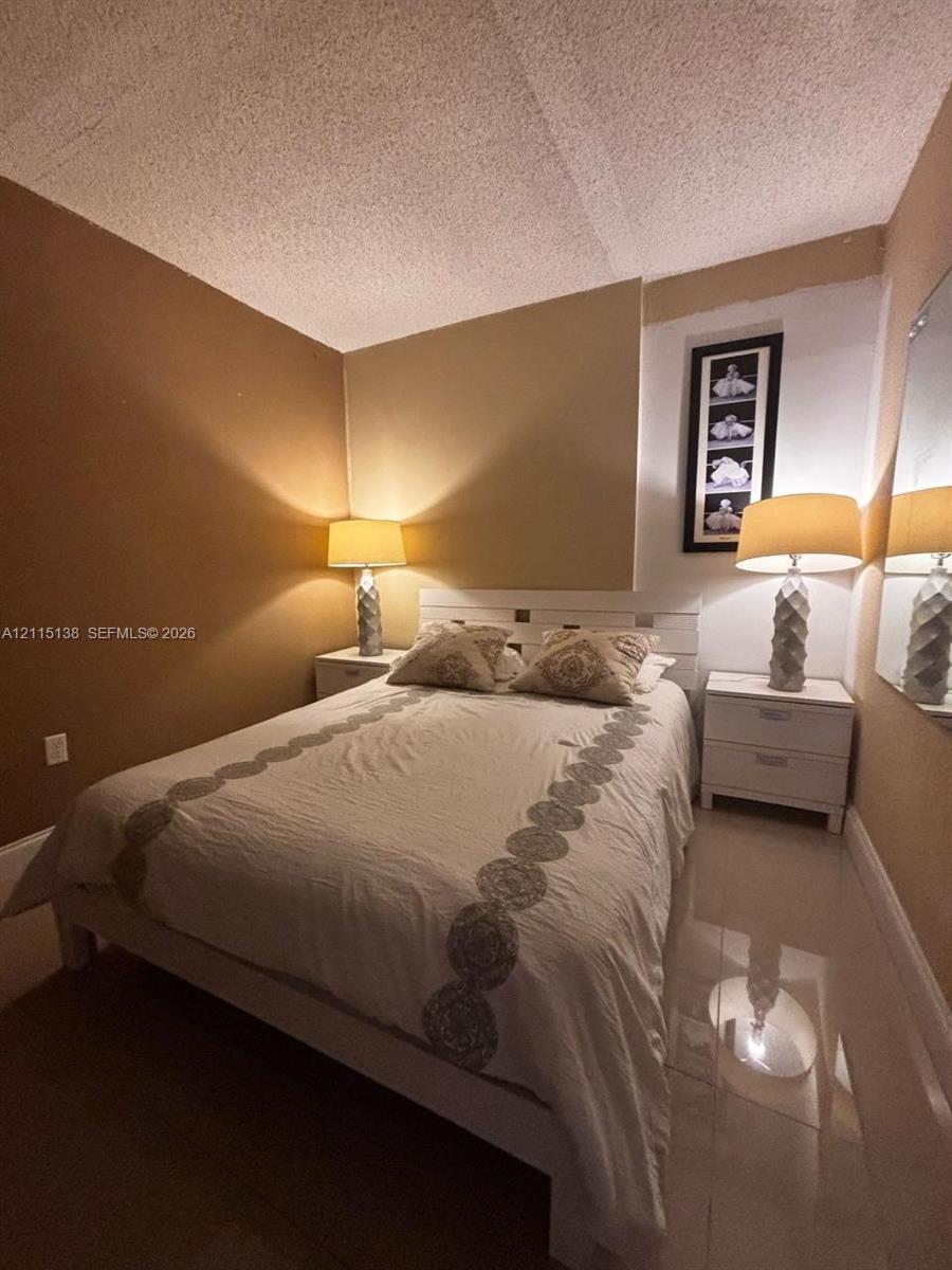 Neutral-toned walls paired with polished light-reflective flooring and a textured ceiling finish