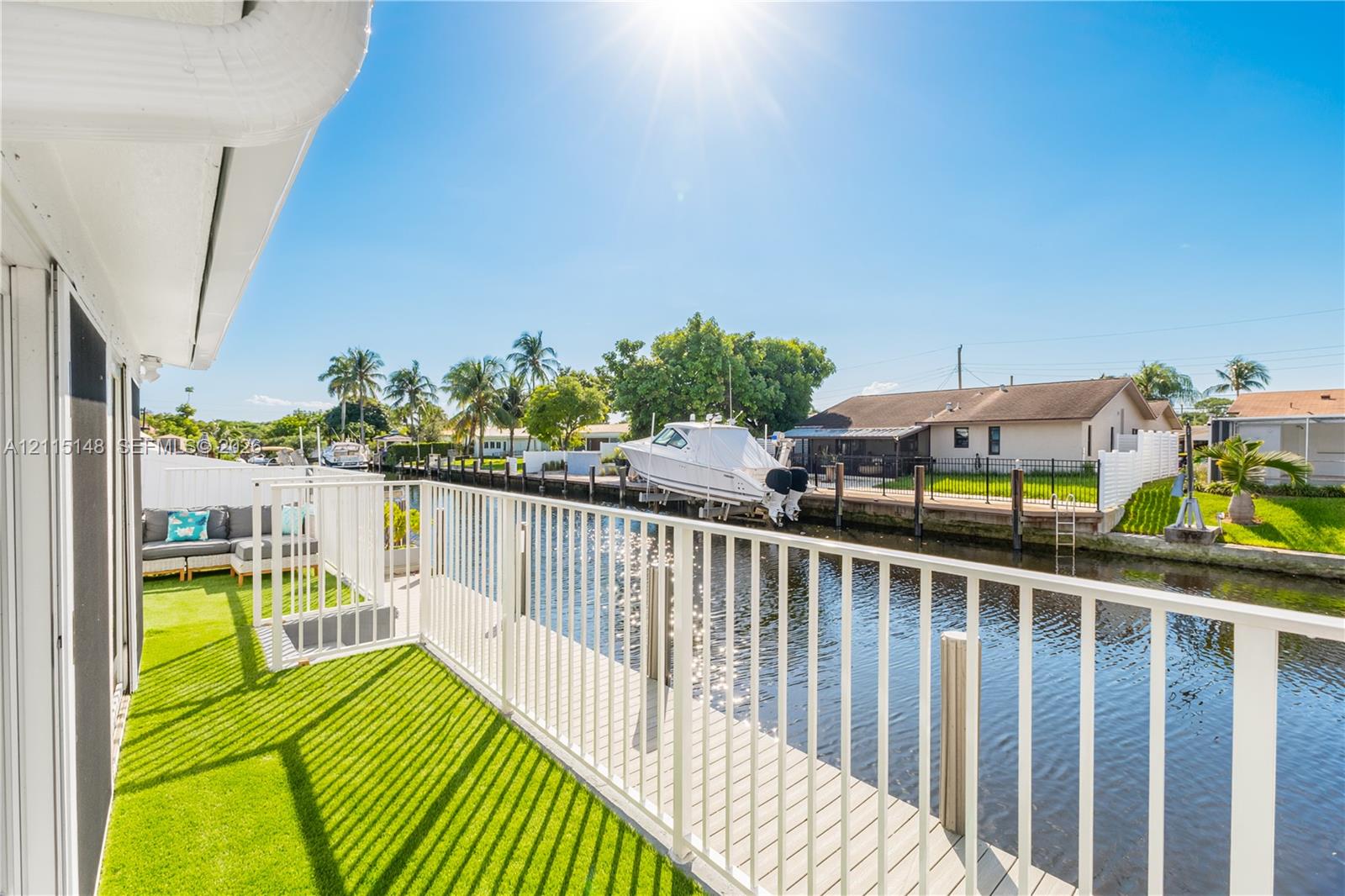Waterfront deck featuring synthetic turf flooring, vertical baluster railing, and direct water access Waterfront deck featuring synthetic turf flooring, vertical baluster railing, and direct water access
