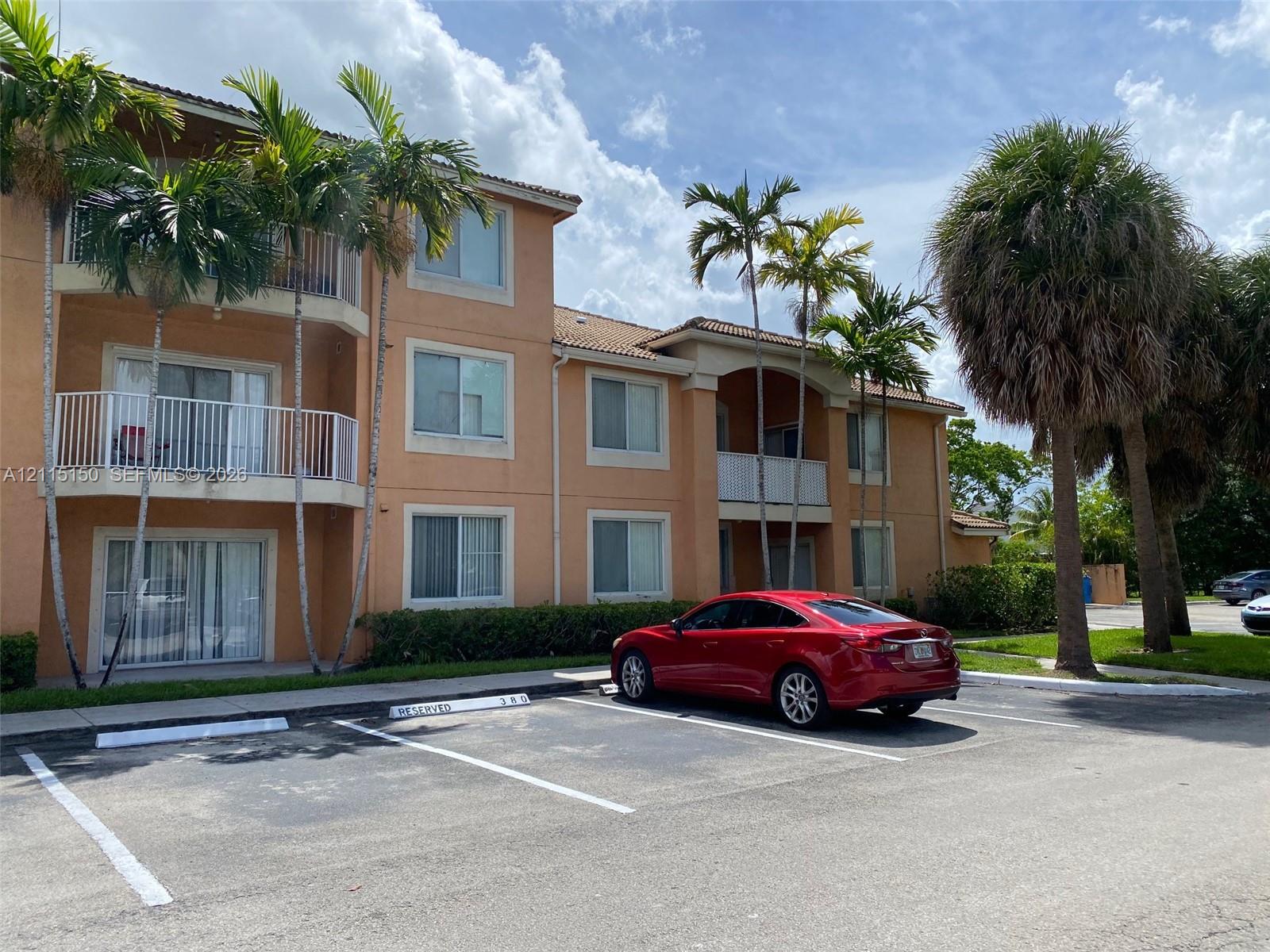 Multi-level exterior featuring stucco siding, tiled roof, private balconies with metal railings, and reserved parking spaces