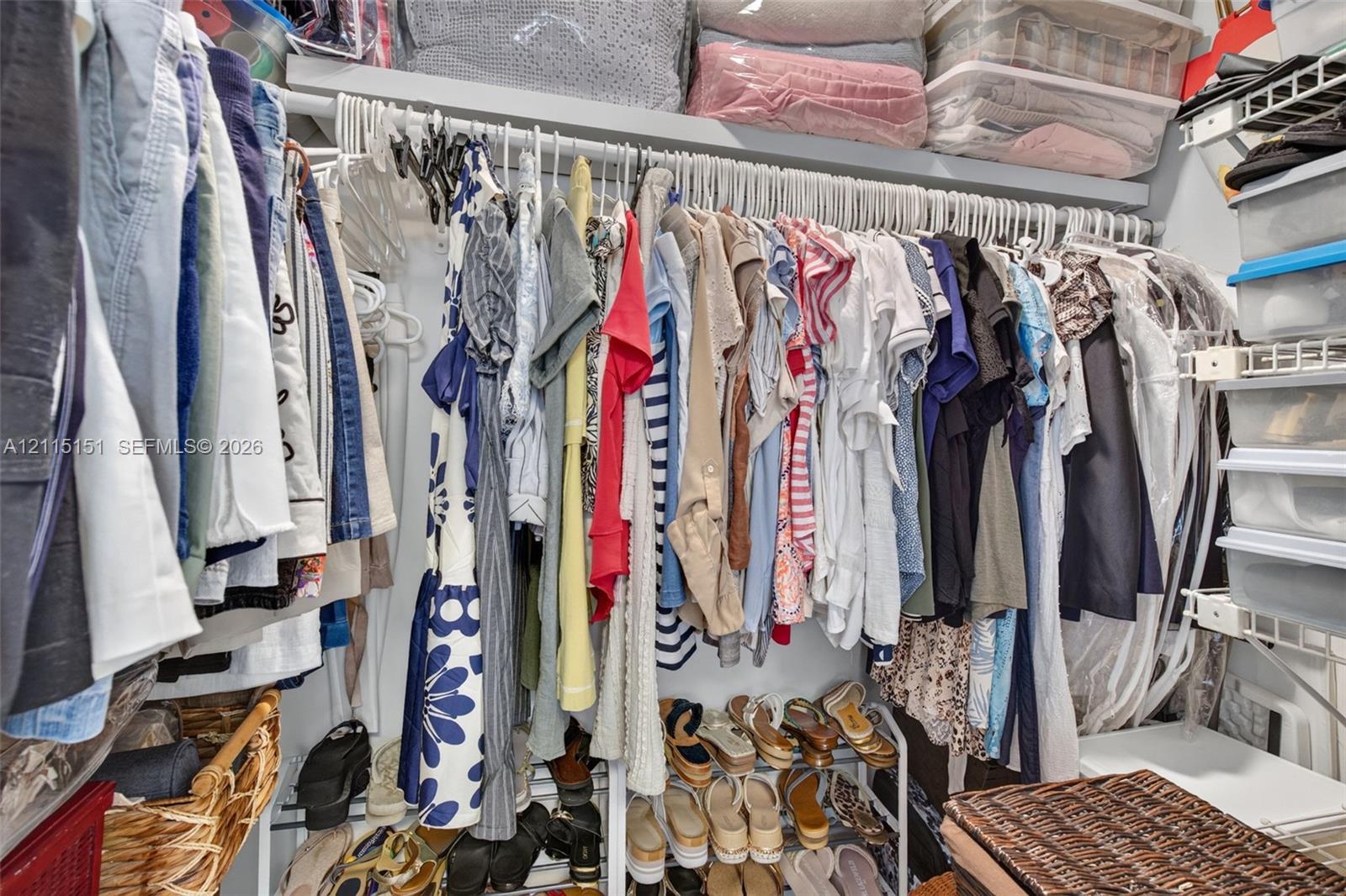 Walk-in closet featuring multi-tiered wire shelving and integrated overhead storage racks