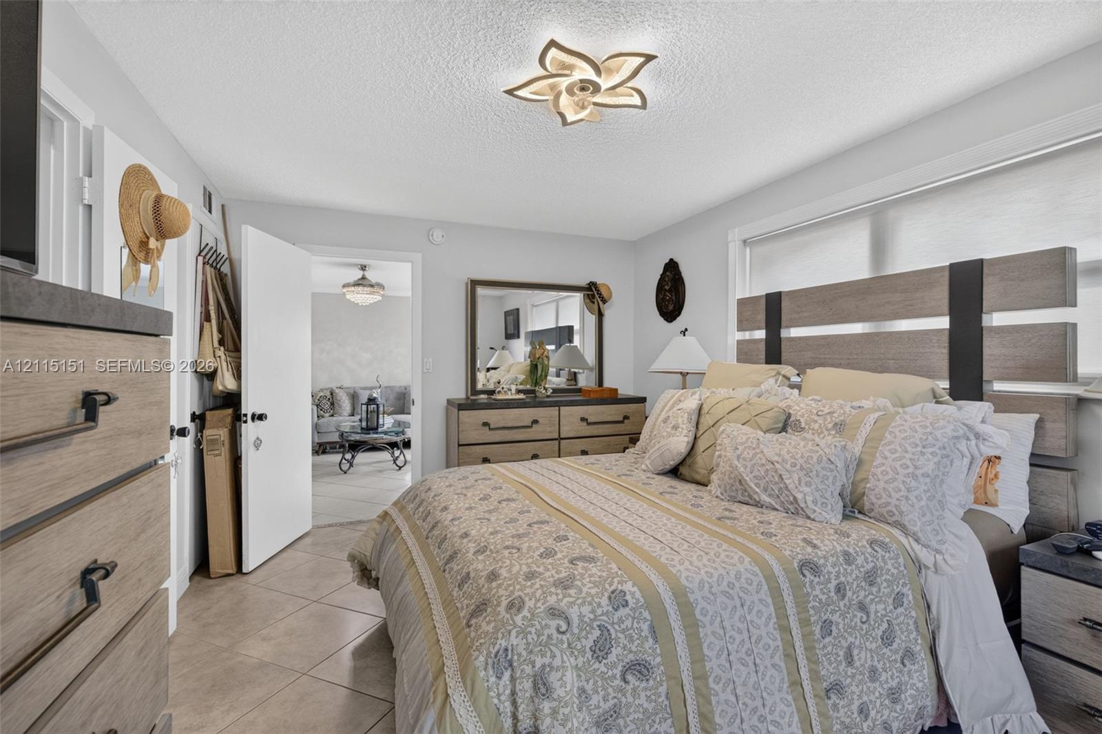 Ceramic tile flooring, multi-paneled window, and architectural floral-patterned flush-mount ceiling lighting