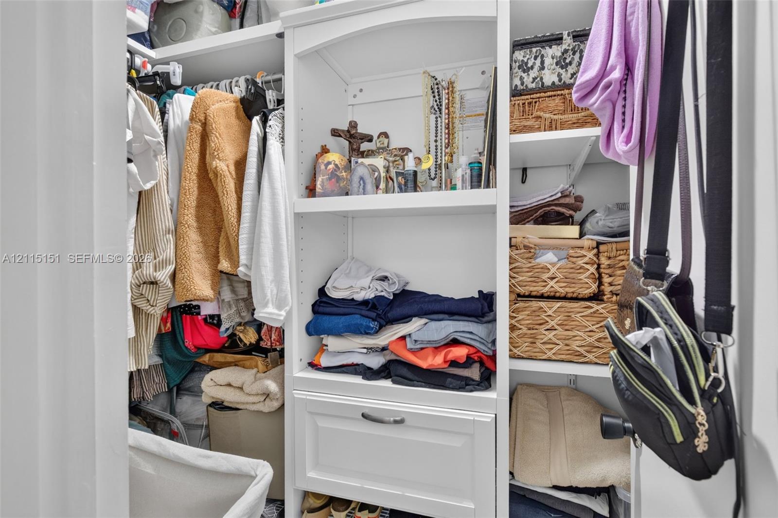 Custom built-in closet organization featuring adjustable shelving, integrated storage drawer, and overhead display nook