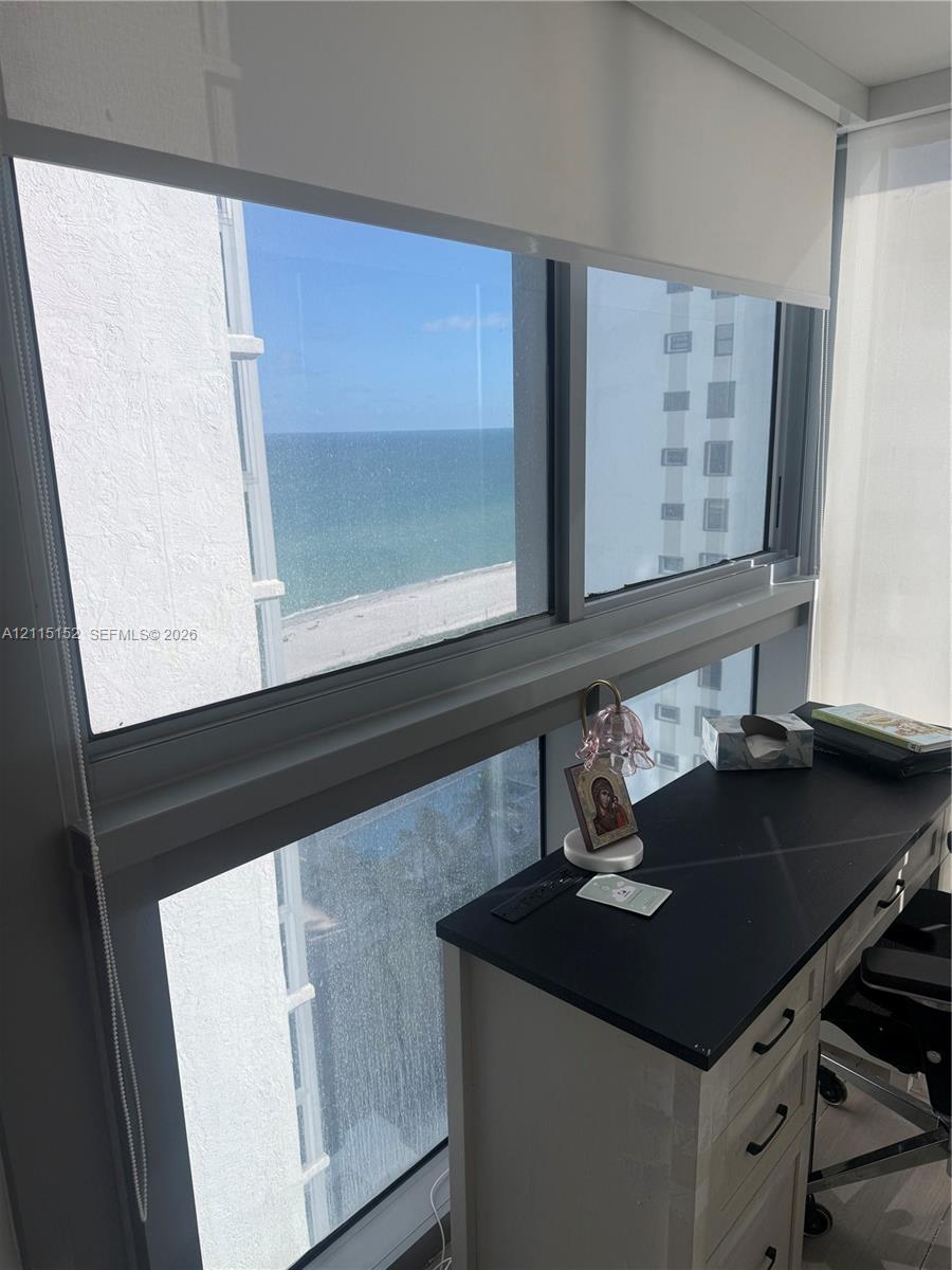Floor-to-ceiling windows featuring silver-toned metal framing and retractable fabric roller shades