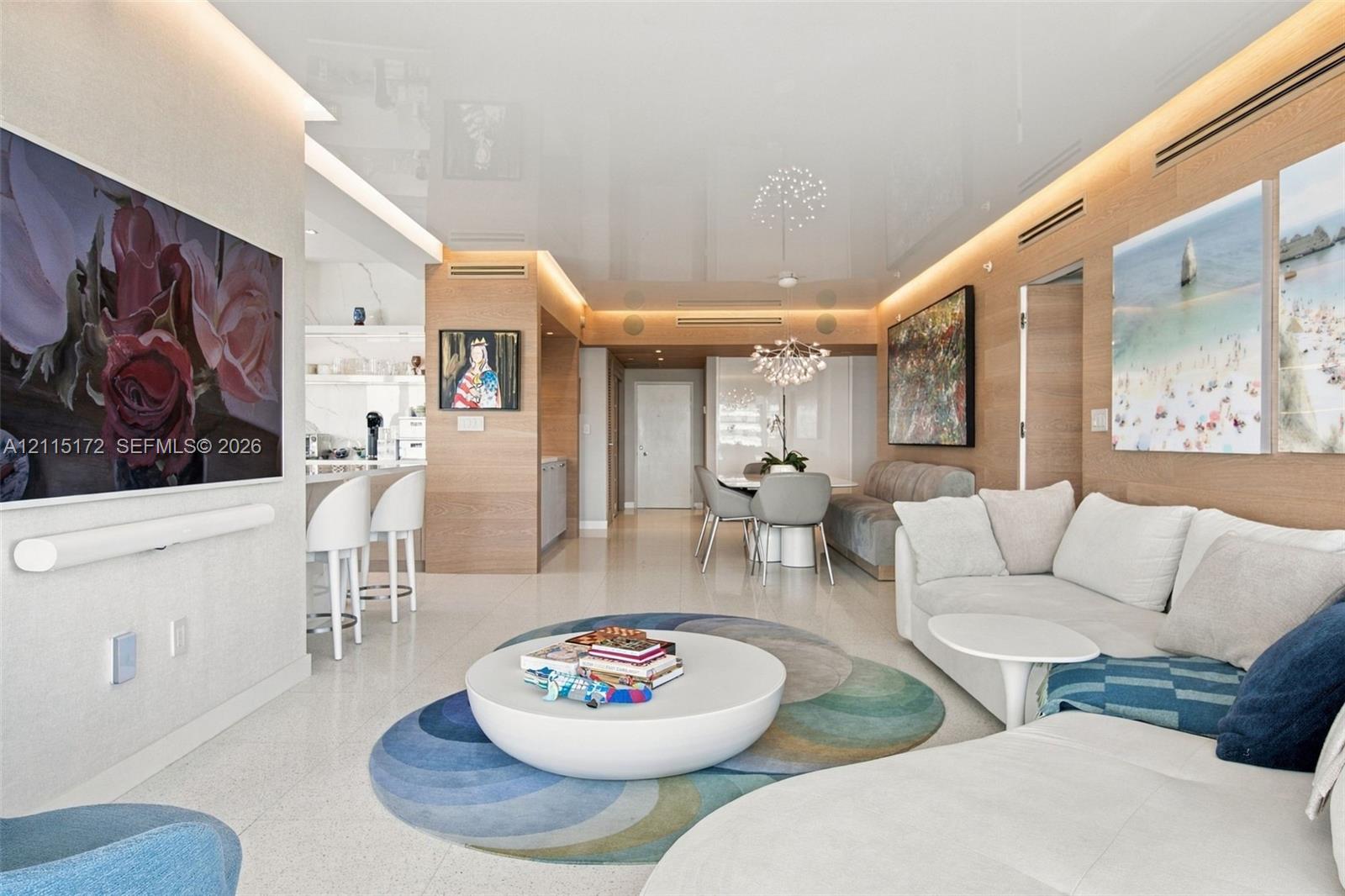 High-gloss ceiling with integrated perimeter recessed lighting, polished stone flooring, and warm wood-panel wall treatments
