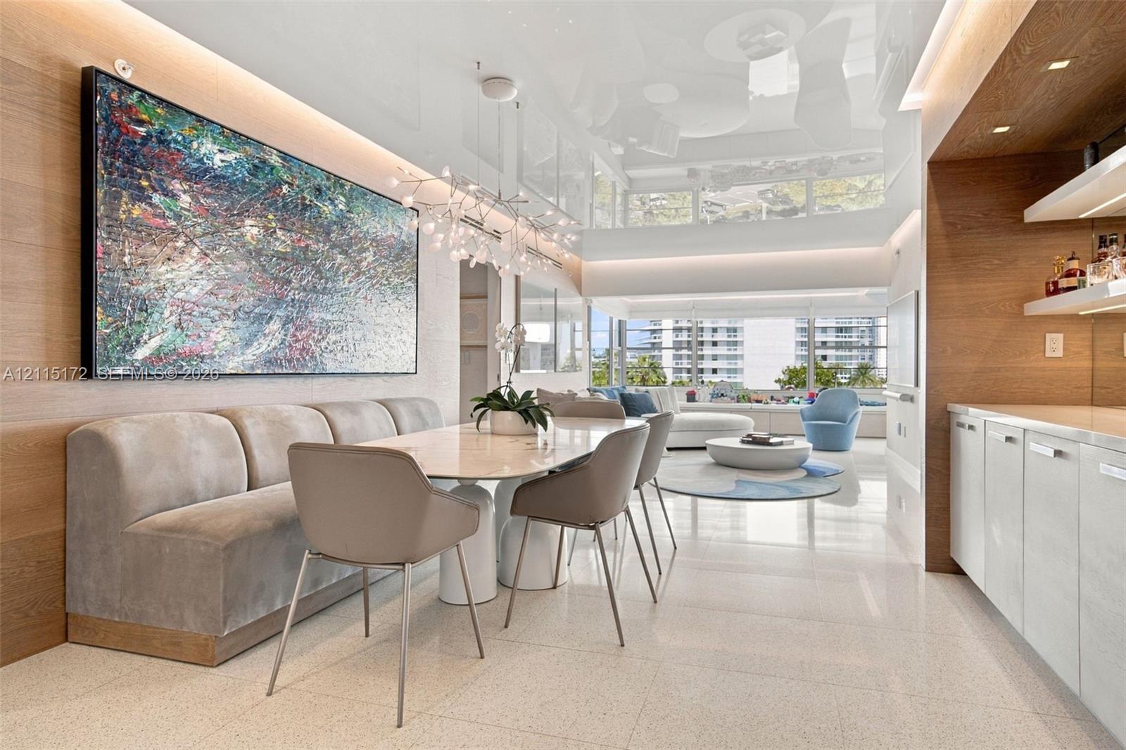 High-gloss ceiling with recessed perimeter lighting, wall-to-wall wood-finish paneling, custom built-in cabinetry with stone-finish countertops, and large-format tile flooring