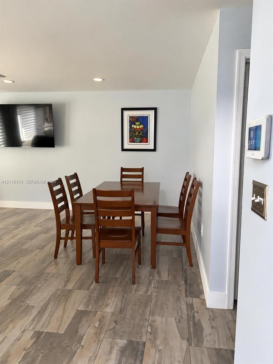 Wood-finish flooring, recessed lighting, and wall-mounted smart home control panel Wood-finish flooring, recessed lighting, and wall-mounted smart home control panel