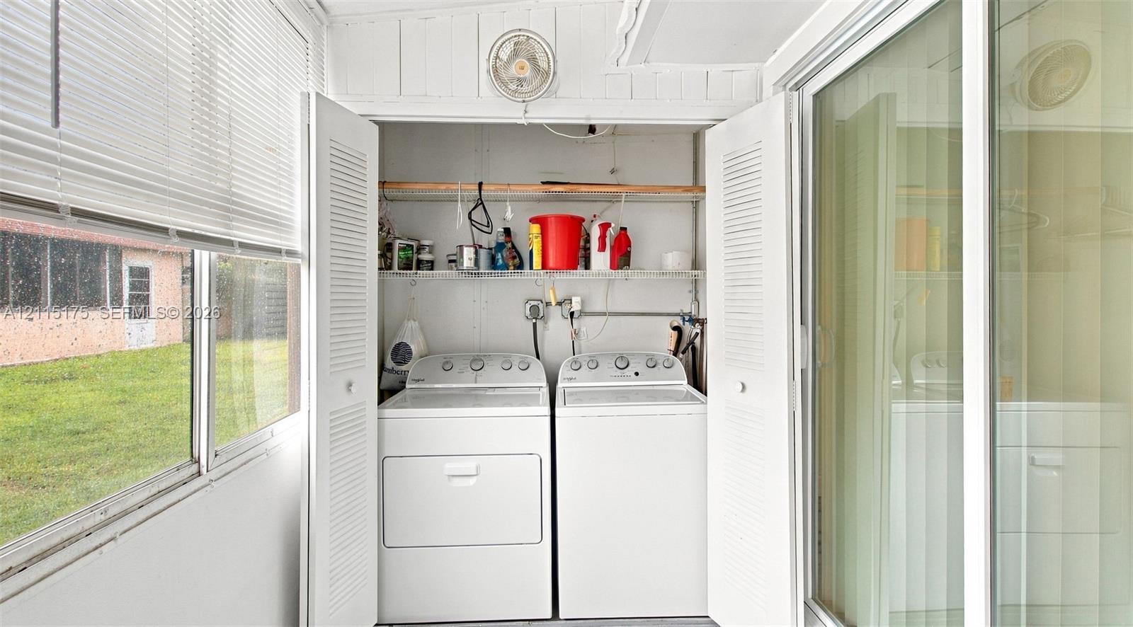 Laundry area featuring louvered bi-fold closet doors and wall-mounted shelving