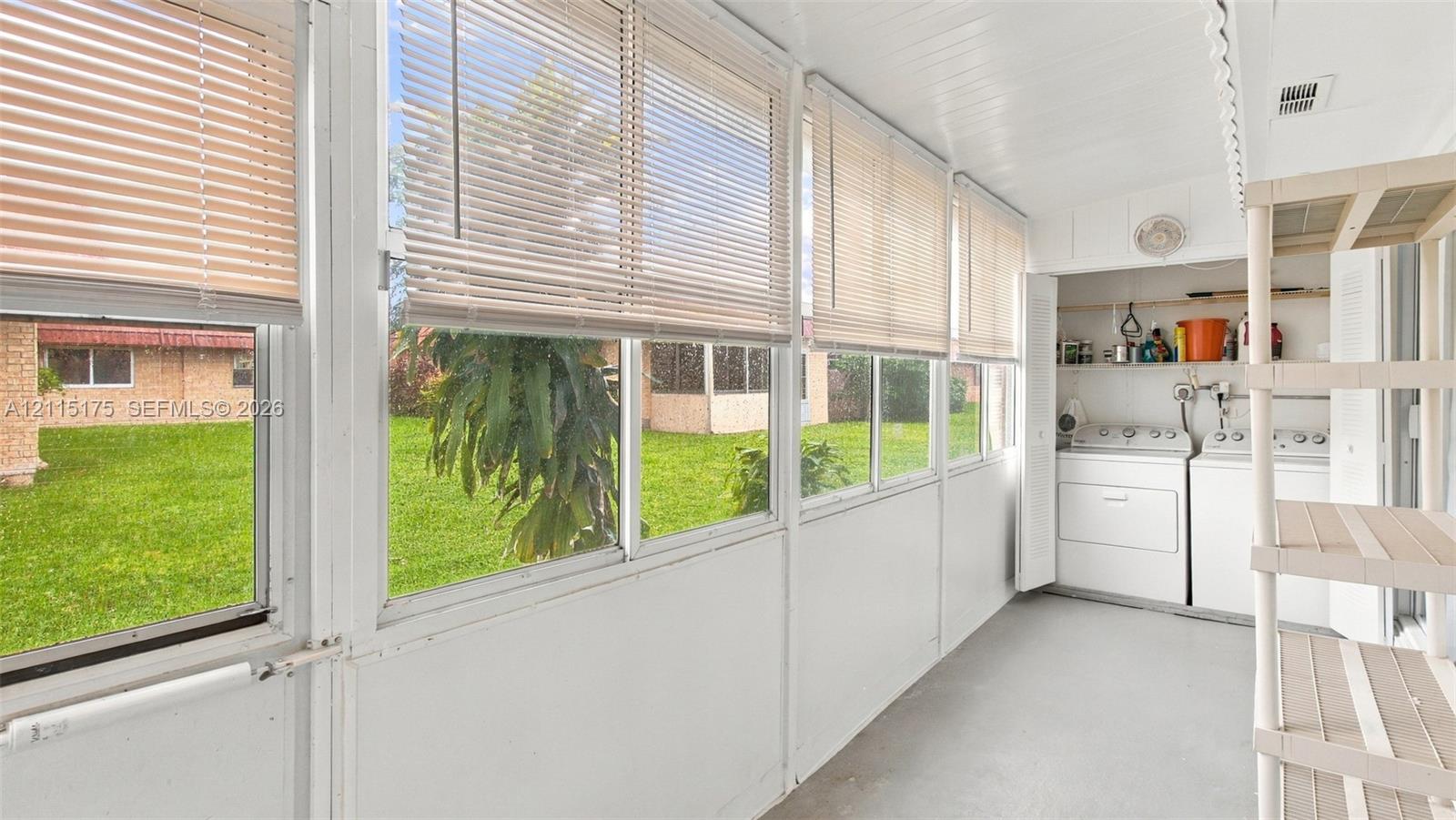 Enclosed lanai featuring expansive windows with horizontal blinds, beadboard ceiling, and integrated laundry area with closet storage