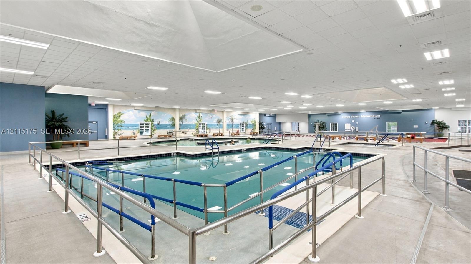 Natatorium with lap pool, wading pool, resistance pool and whirlpool. The facility also features a concrete deck, metal safety railings, integrated skylights, and ceiling-mounted lighting