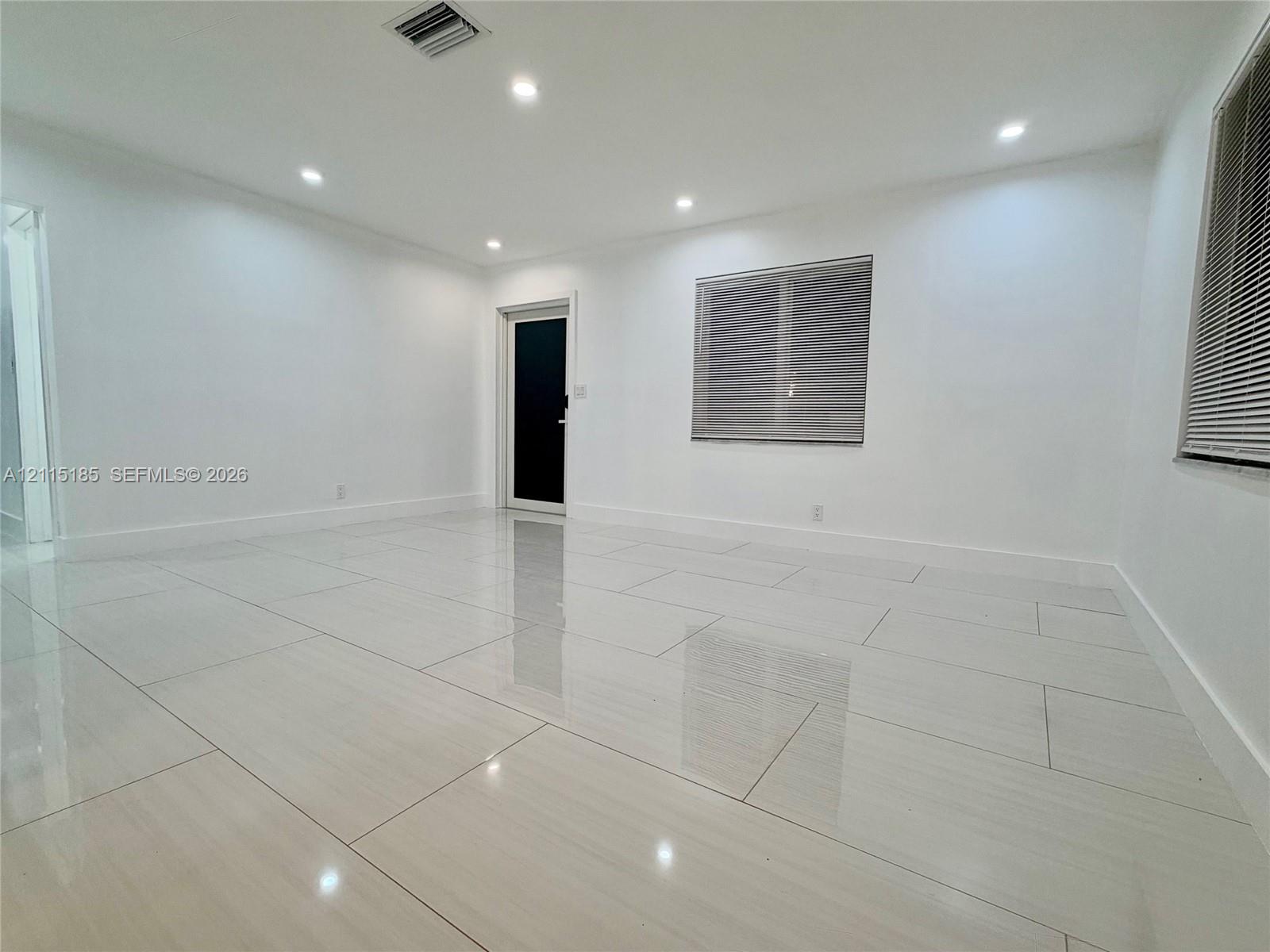 Interior space featuring large-format polished tile flooring, recessed LED ceiling lighting, and a neutral color palette