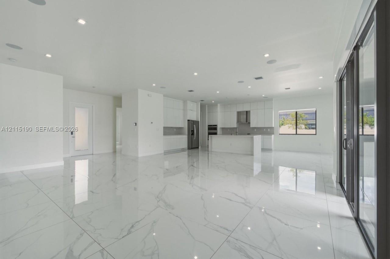 Open living area, kitchen and patio access.