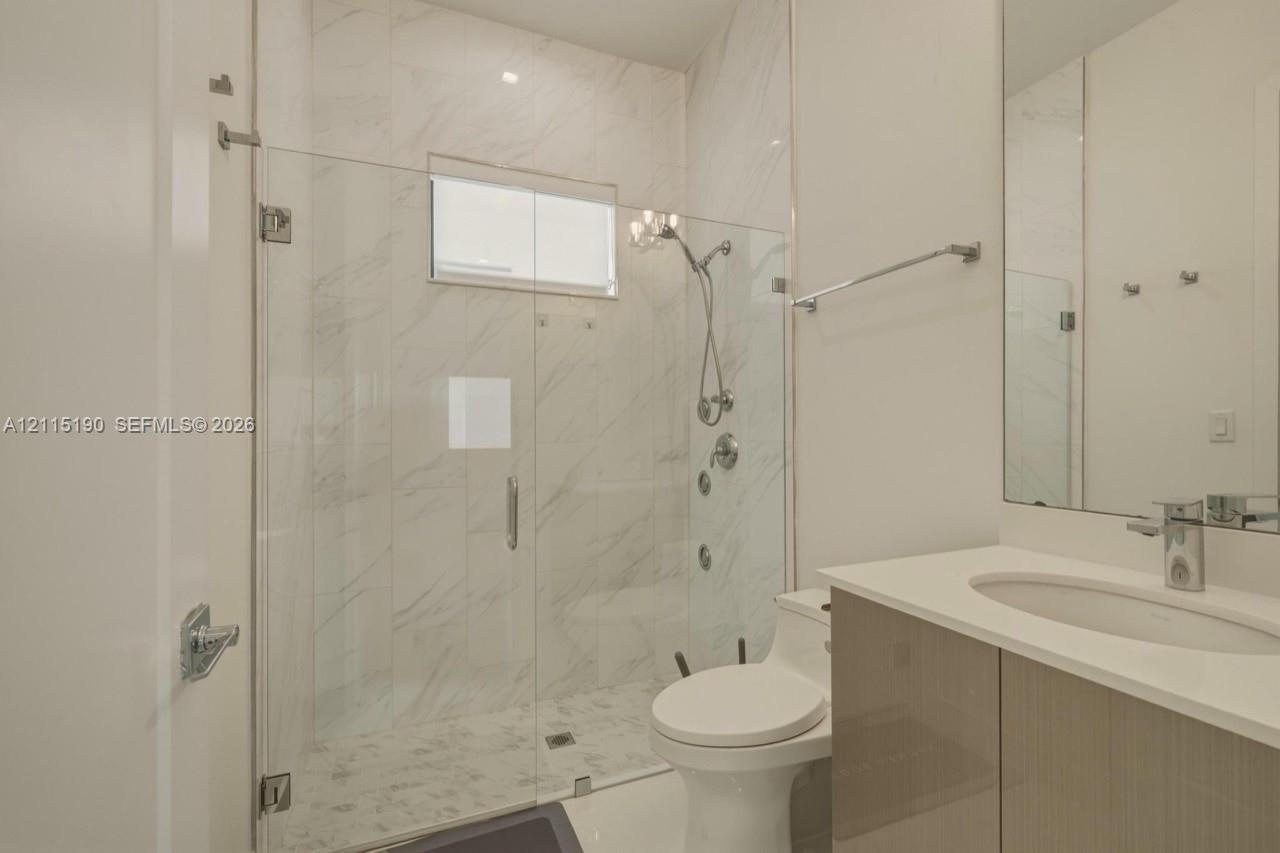 Full bathroom with glass-enclosed shower.