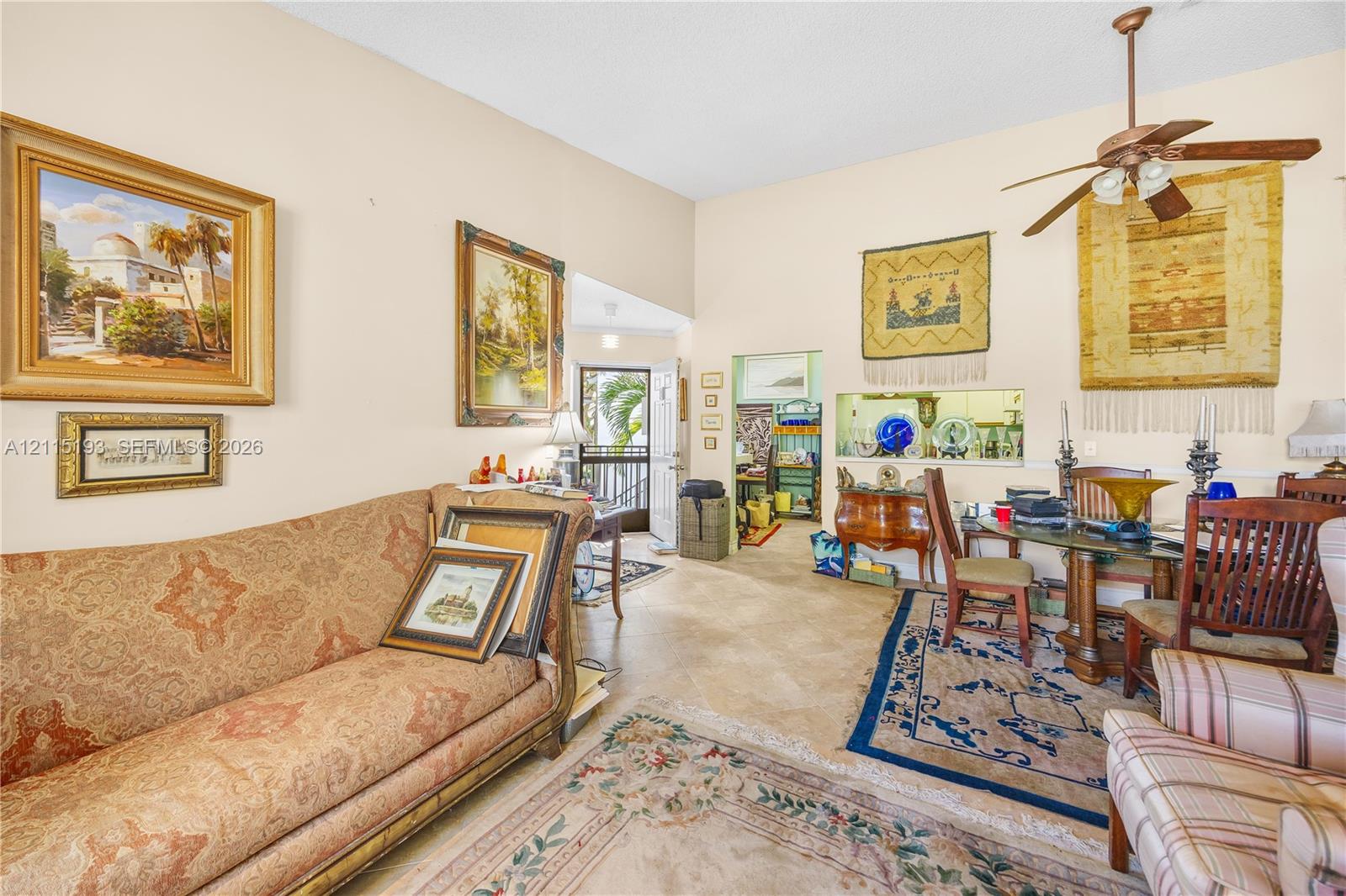High ceilings, neutral wall tones, tile flooring, and a ceiling fan with integrated lighting