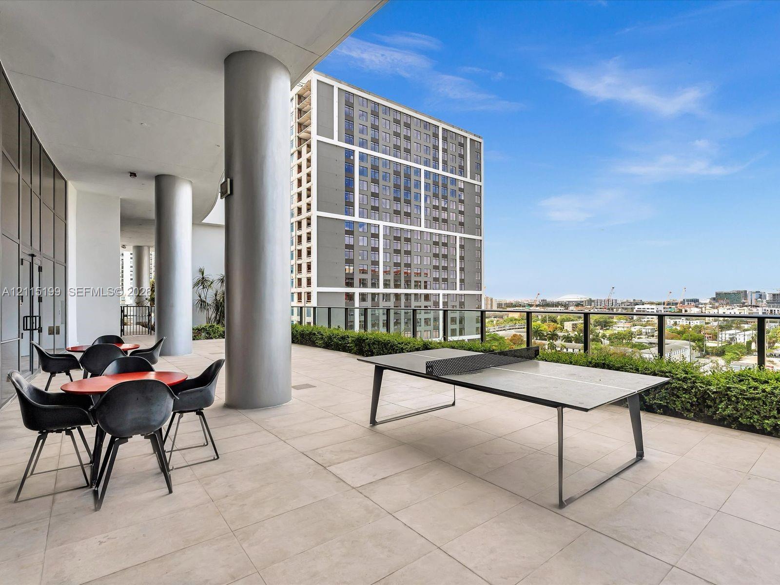 Covered terrace featuring large-format tile flooring, structural columns, and glass-and-metal perimeter railings