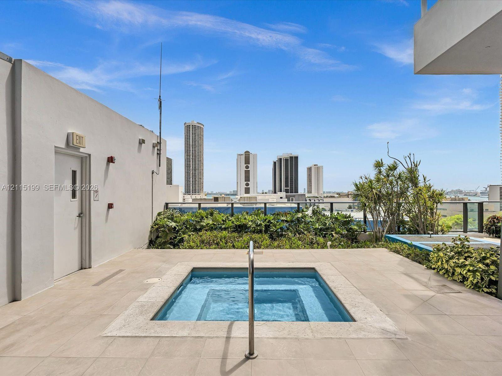 Rooftop terrace featuring an in-ground spa, tiled flooring, integrated landscaping, and metal perimeter railing