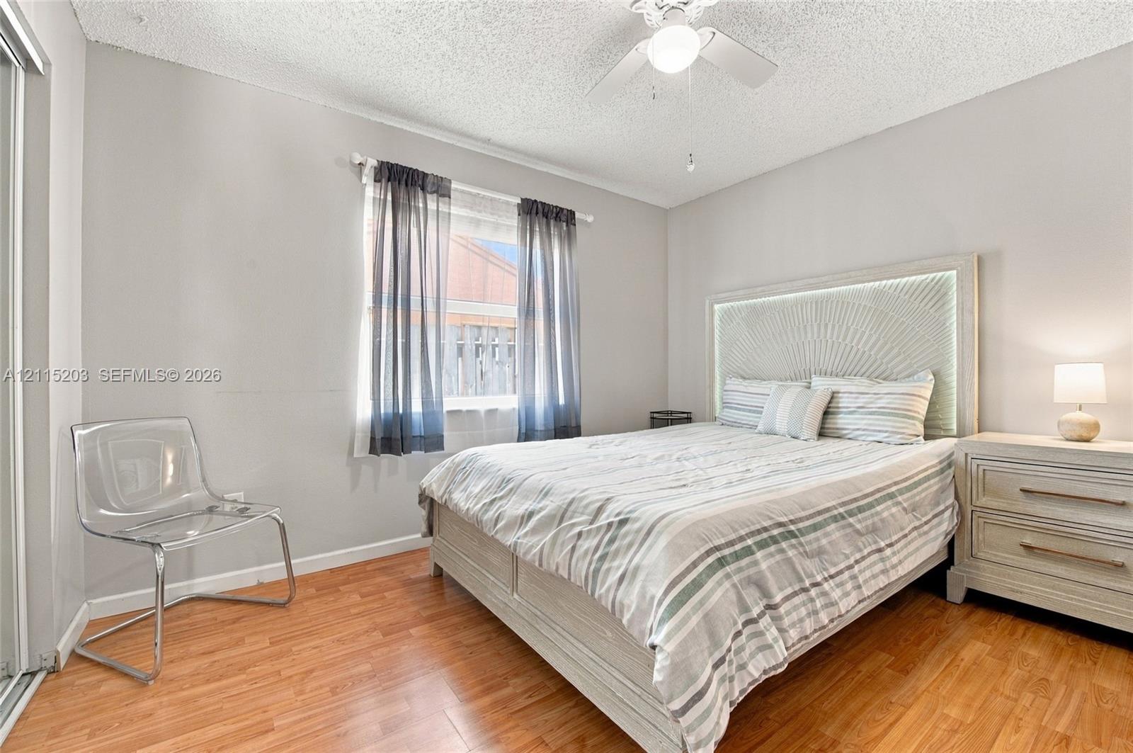 Wood-finish flooring, neutral wall paint, and a central ceiling fan with an integrated light fixture