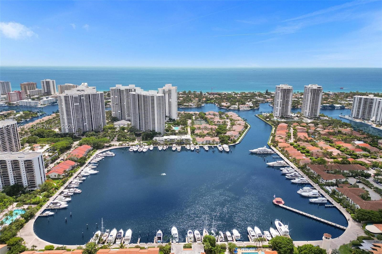 Aerial perspective of a deep-water marina featuring showing proximity to the ocean.
