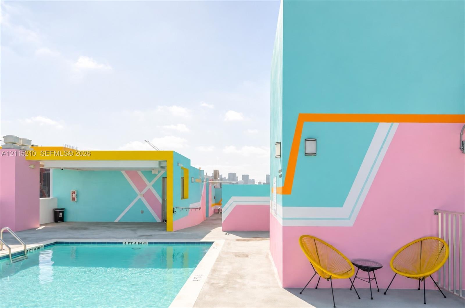 Rooftop terrace featuring an in-ground swimming pool, smooth concrete decking, geometric wall murals, and metallic perimeter railings