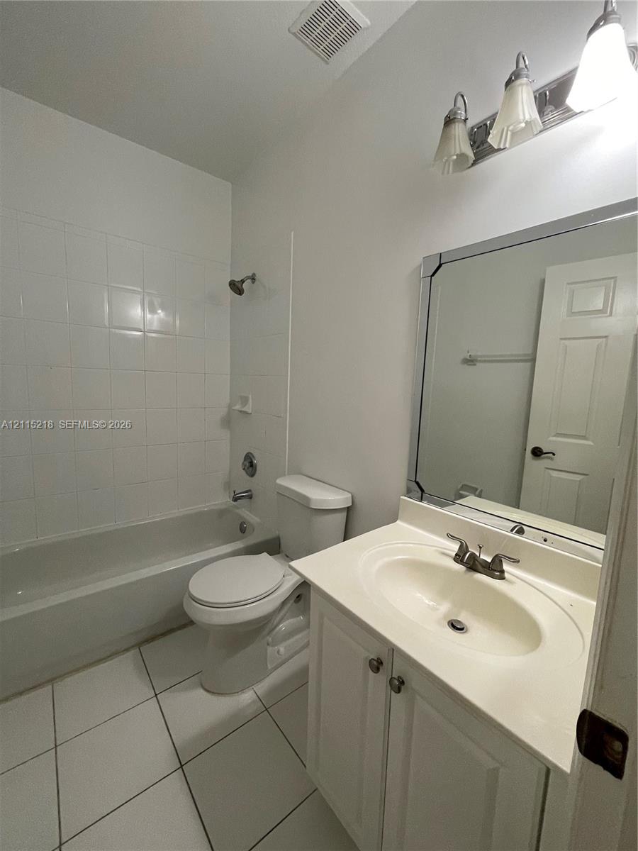 Laundry area featuring a multi-pane window, white wire shelving, and tile flooring
