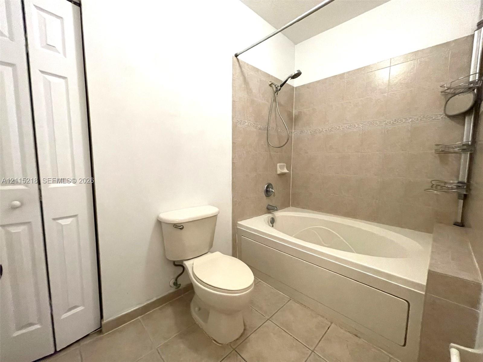 Bathroom featuring a vanity with an integrated sink, a tiled tub-shower combination, a framed mirror, and a three-light fixture