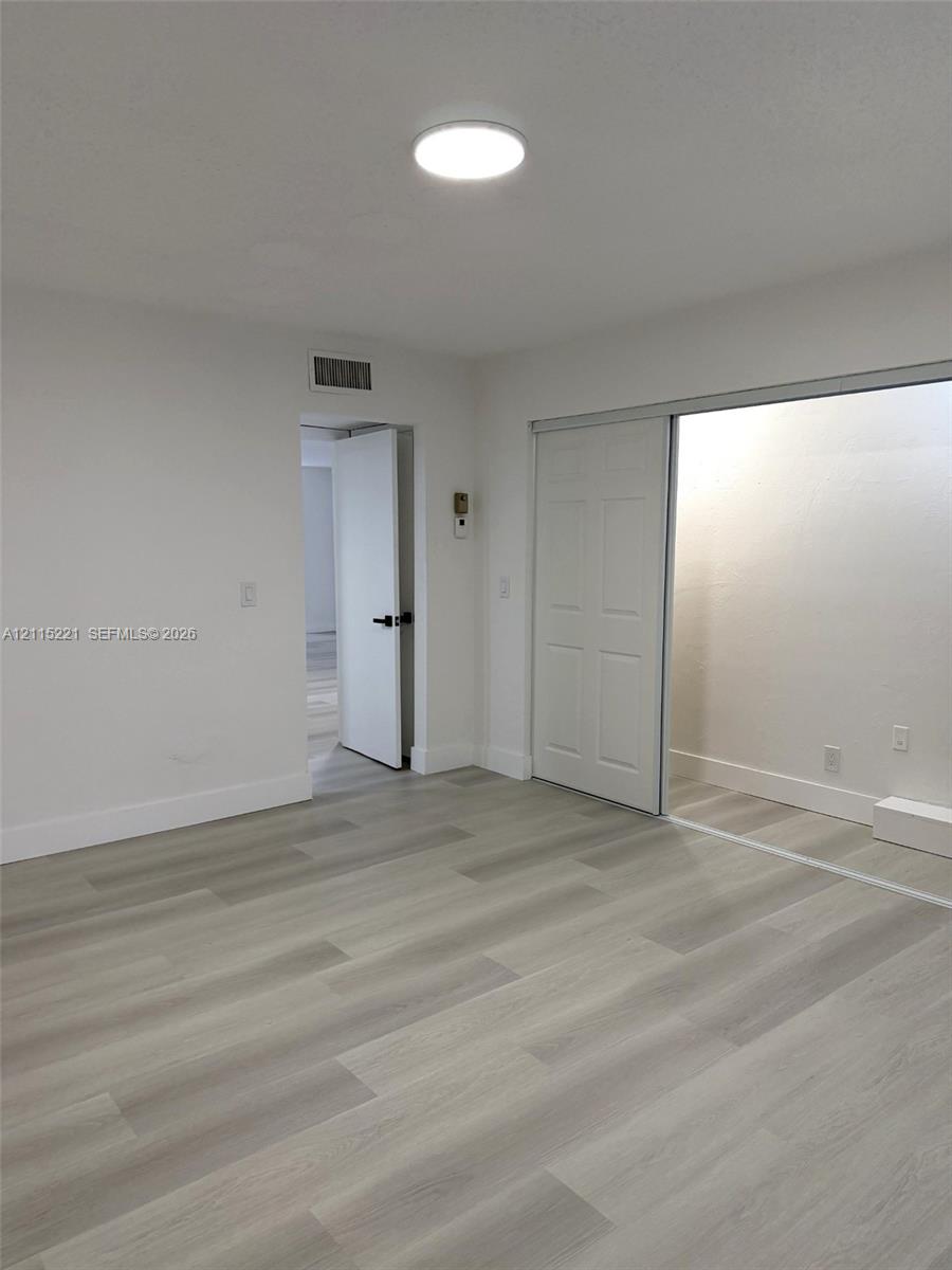 Interior space featuring wood-finish flooring, recessed LED ceiling lighting, and a sliding-door closet