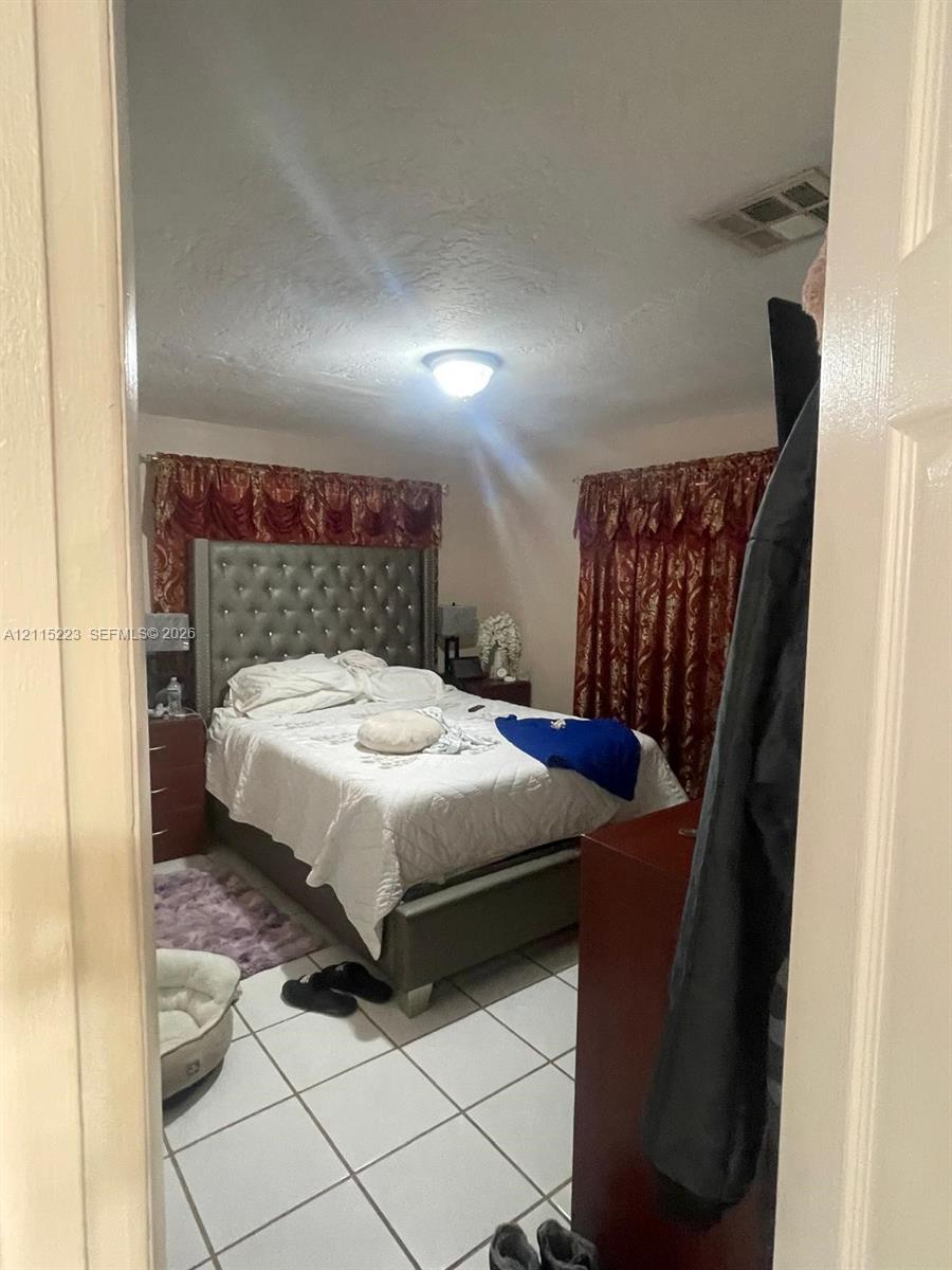 Room featuring white tile flooring and a central ceiling-mounted light fixture