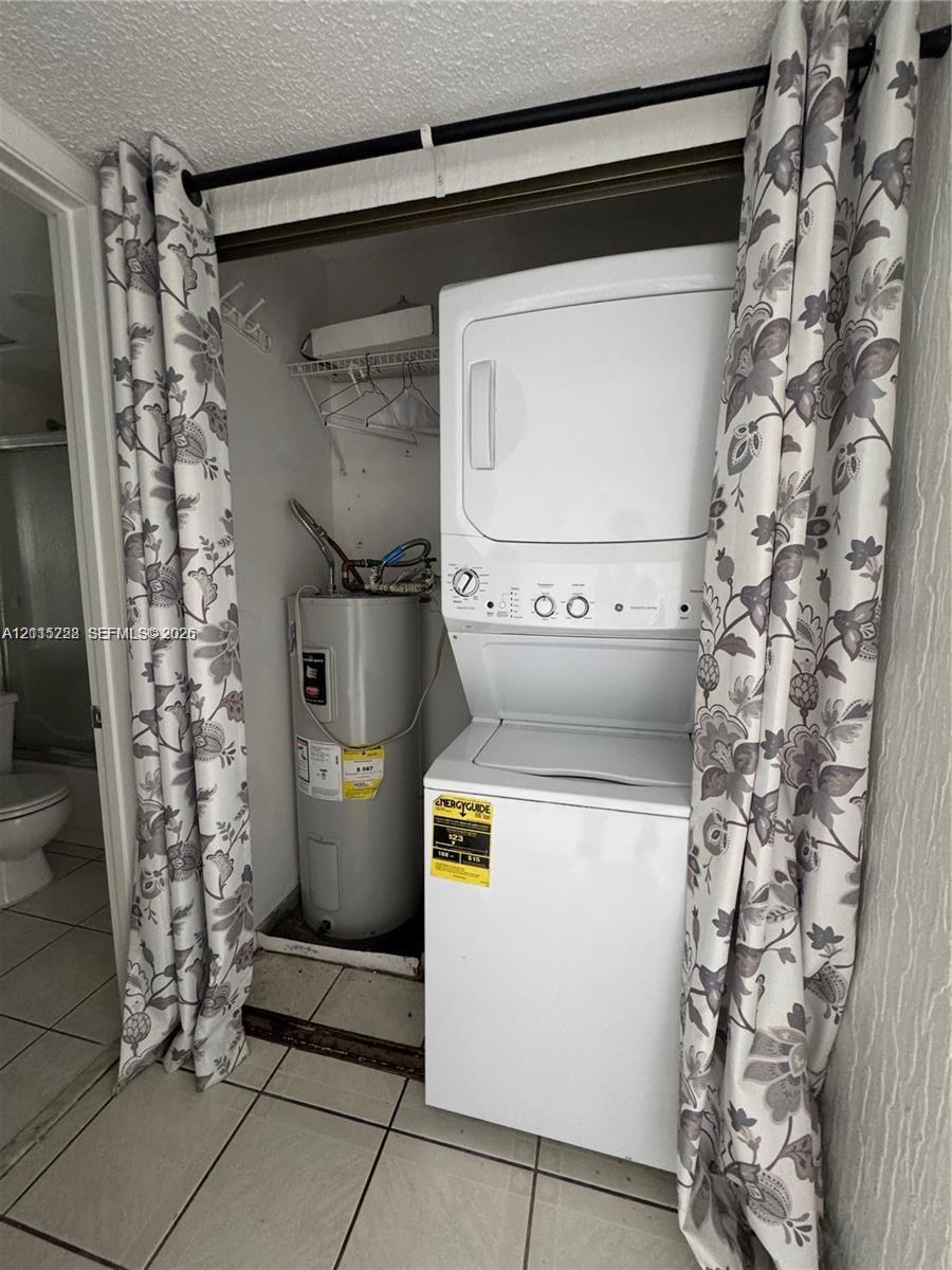 Stacked laundry unit with an integrated water heater and wire shelving