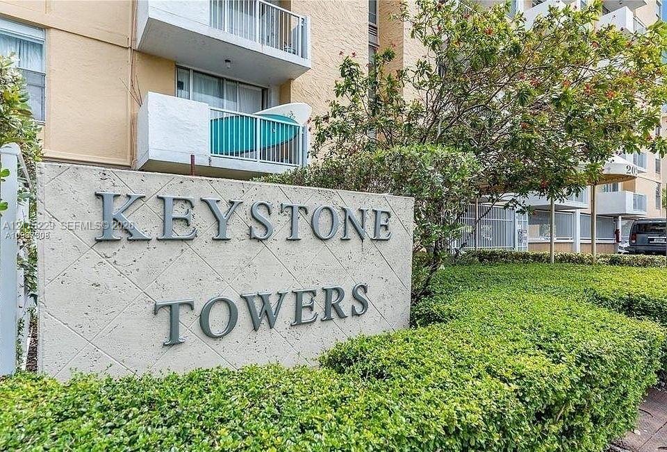 Textured concrete monument sign featuring dimensional lettering, framed by manicured hedges and mature landscaping