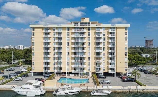 Multi-story residential building featuring exterior balconies, an in-ground swimming pool, and concrete bulkhead boat slips