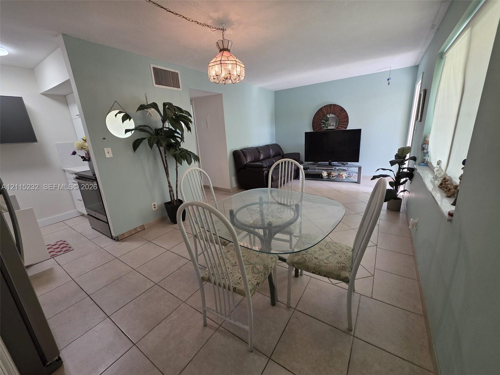 Ceramic tile flooring, glass-paned pendant lighting, and stainless steel kitchen appliances
