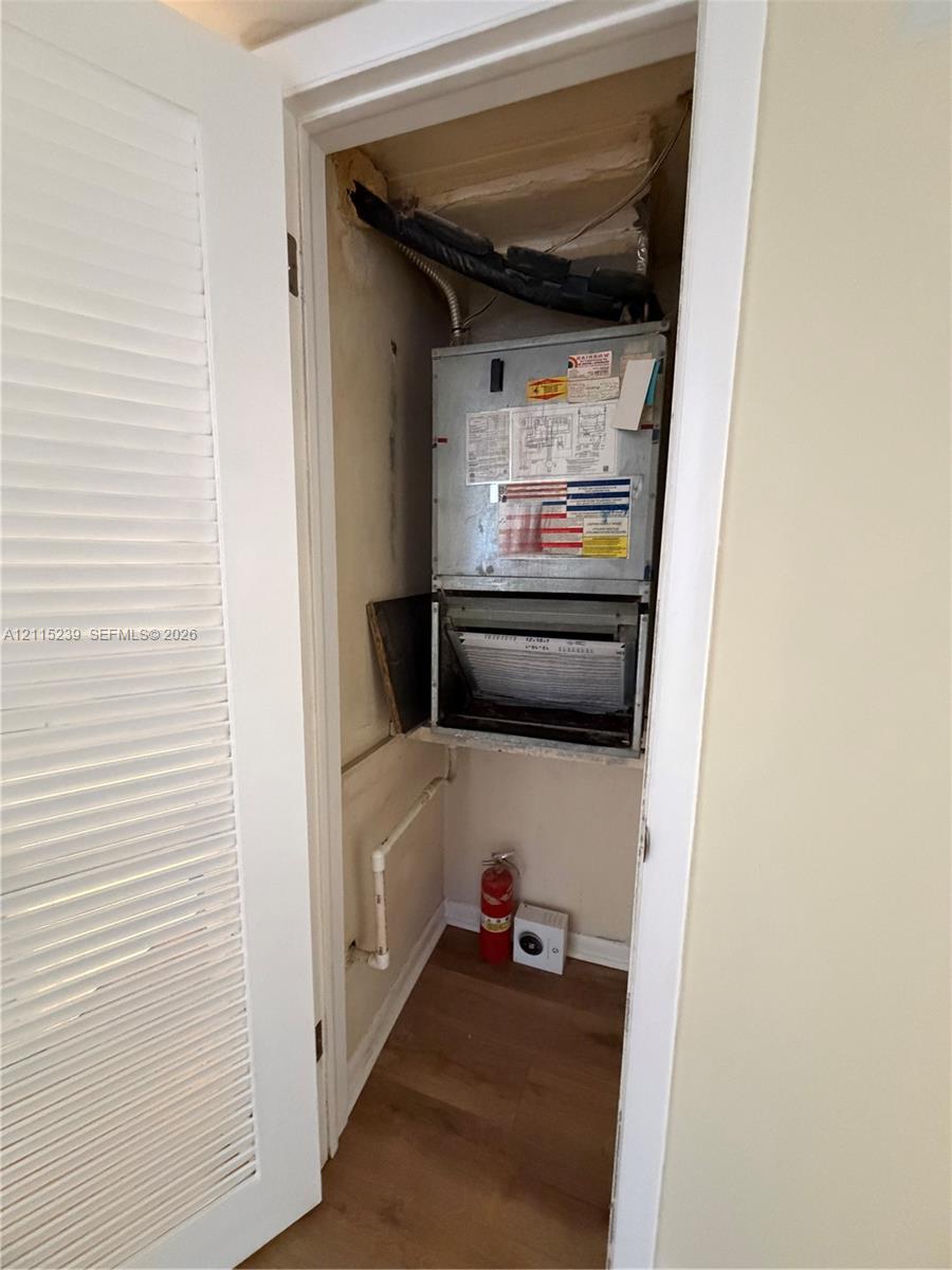 Mechanical closet featuring an HVAC air handler unit and wood-finish flooring