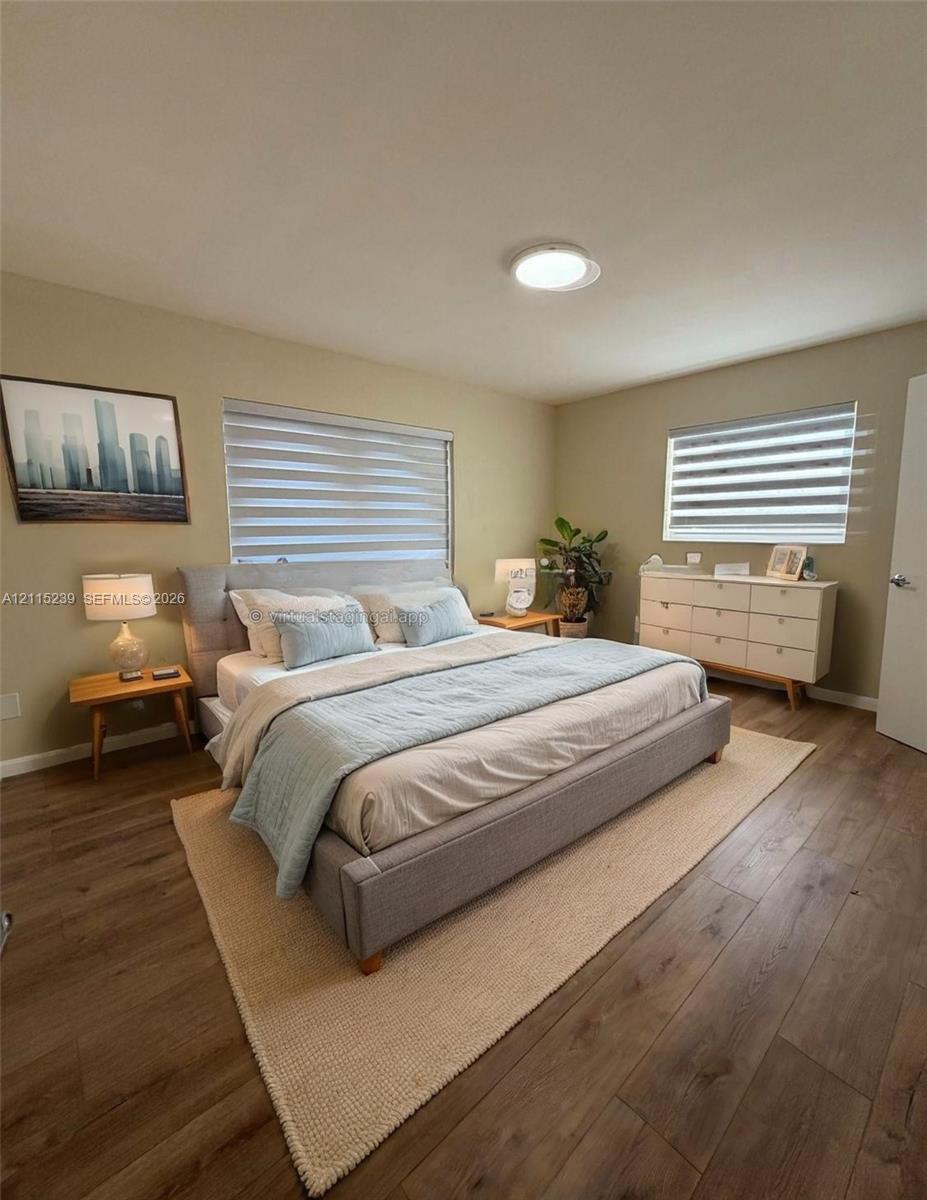 Wood-finish flooring, dual windows with fitted light-filtering shades, and a ceiling-mounted light fixture