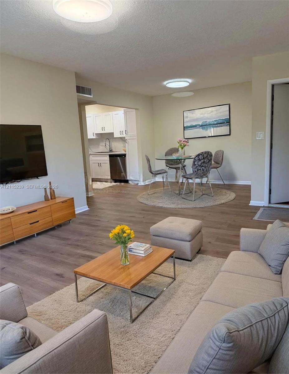 Open-concept interior featuring wood-finish flooring, recessed lighting, and crisp neutral wall tones Open-concept interior featuring wood-finish flooring, recessed lighting, and crisp neutral wall tones