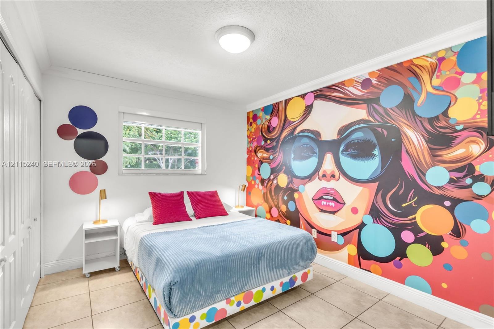 Room featuring large-scale wall mural, tiled flooring, multi-pane window, and double-door closet