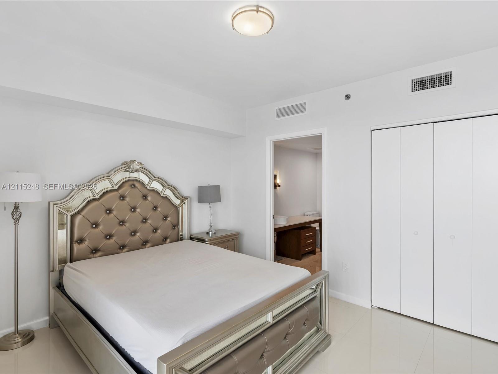 Neutral-toned tile flooring, flush-mount dome lighting, and white bi-fold closet doors