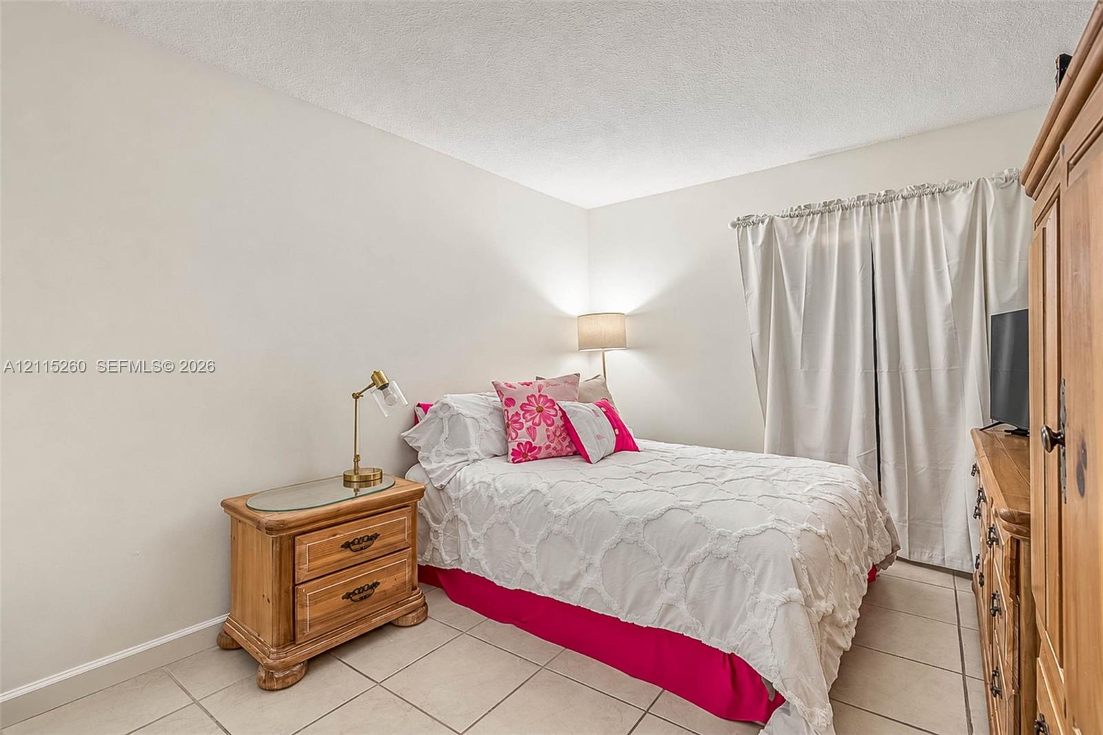Neutral-toned walls, ceramic tile flooring, and floor-to-ceiling drapery