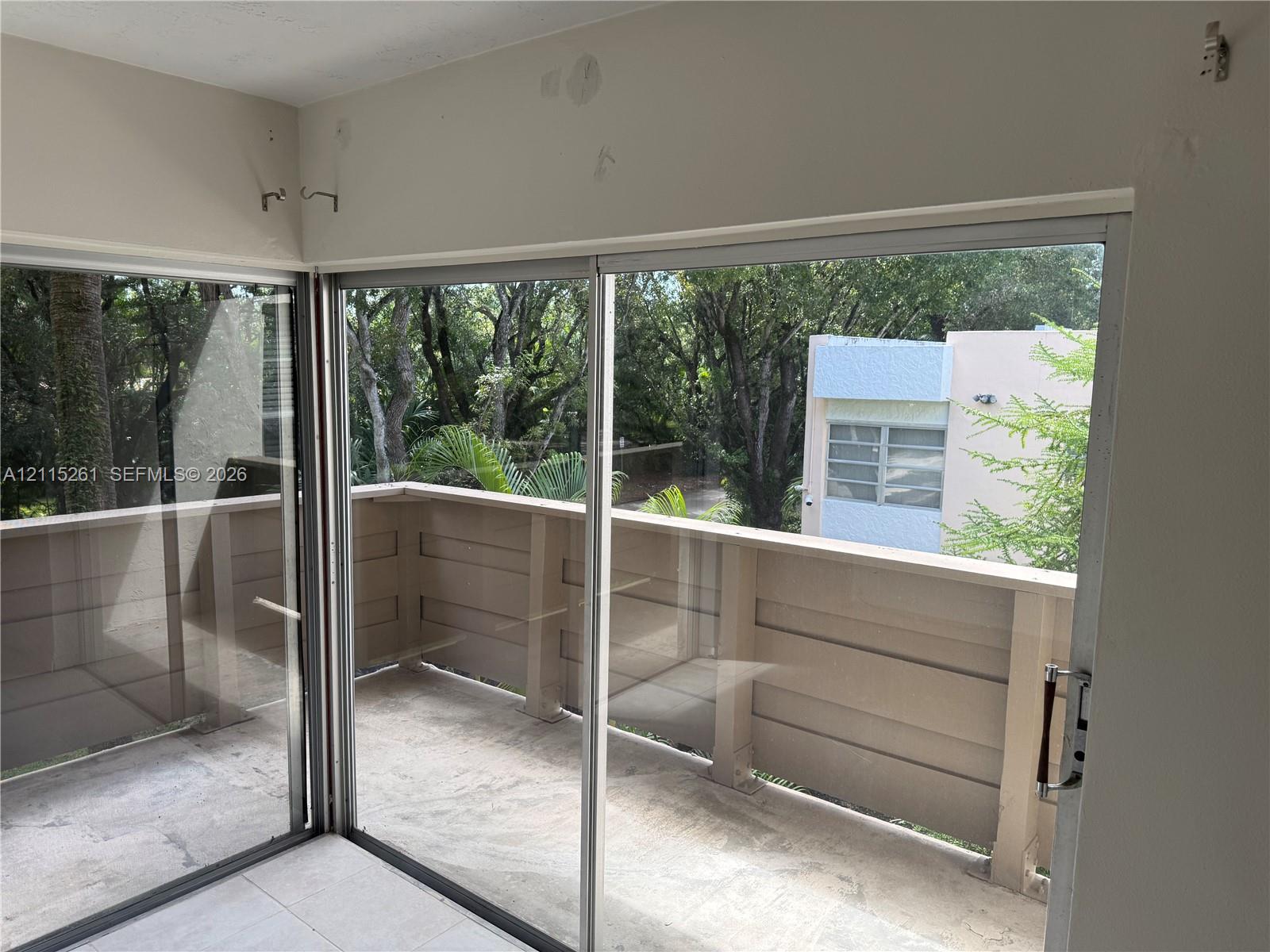 Exterior balcony featuring sliding glass doors and solid panel railing