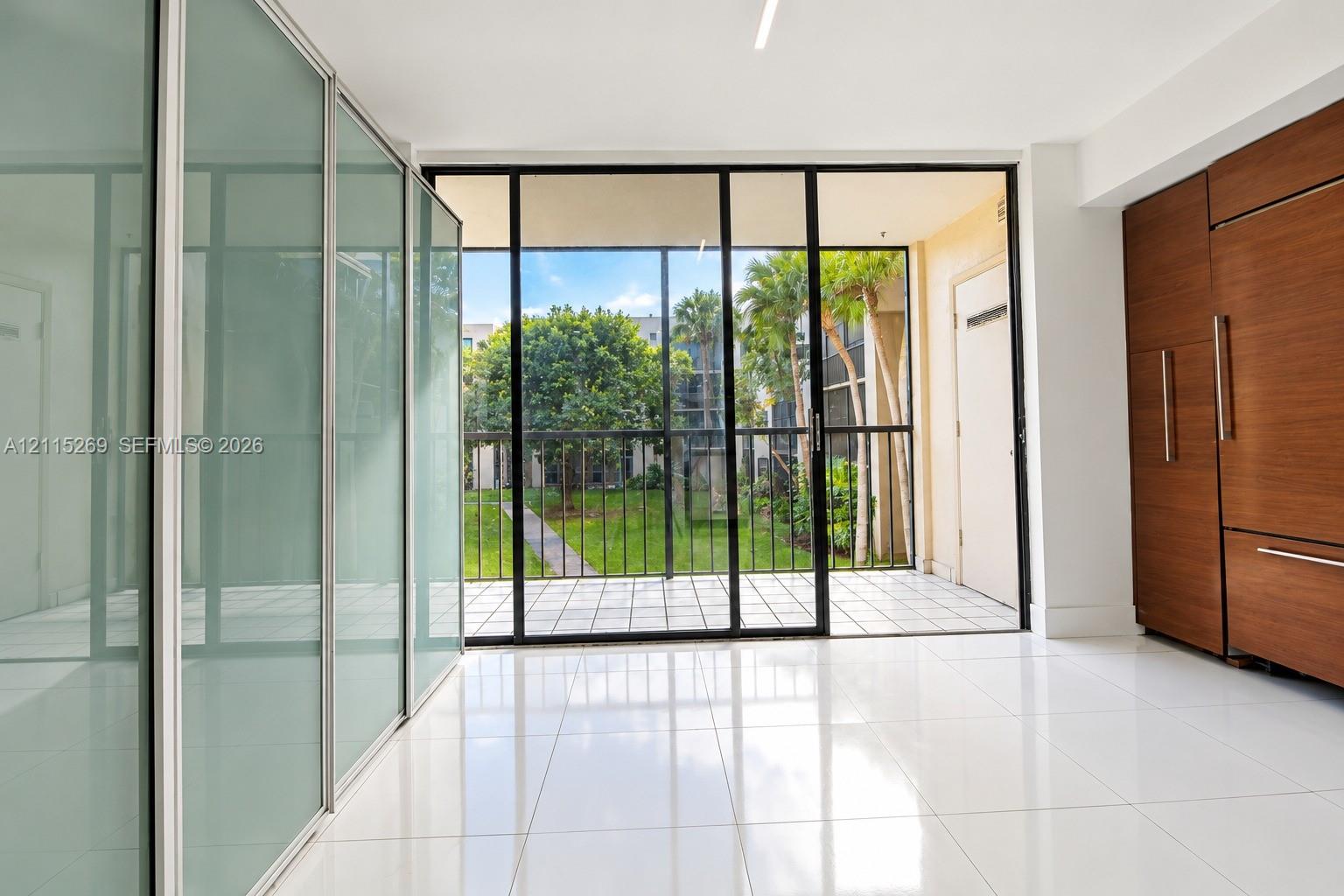 Floor-to-ceiling frosted glass sliding doors, wood-finish built-in cabinetry, polished tile flooring, and a screened patio with black-frame glass sliders