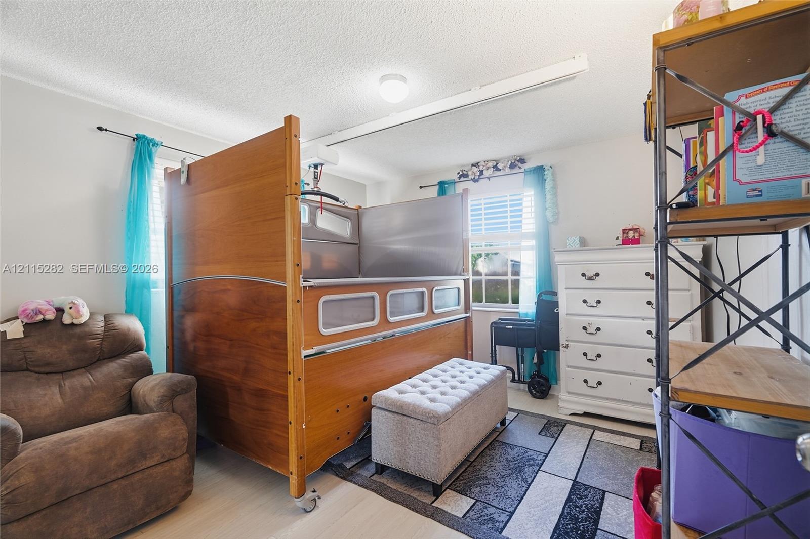 Room featuring a ceiling-mounted track system, dual windows, and light-tone flooring