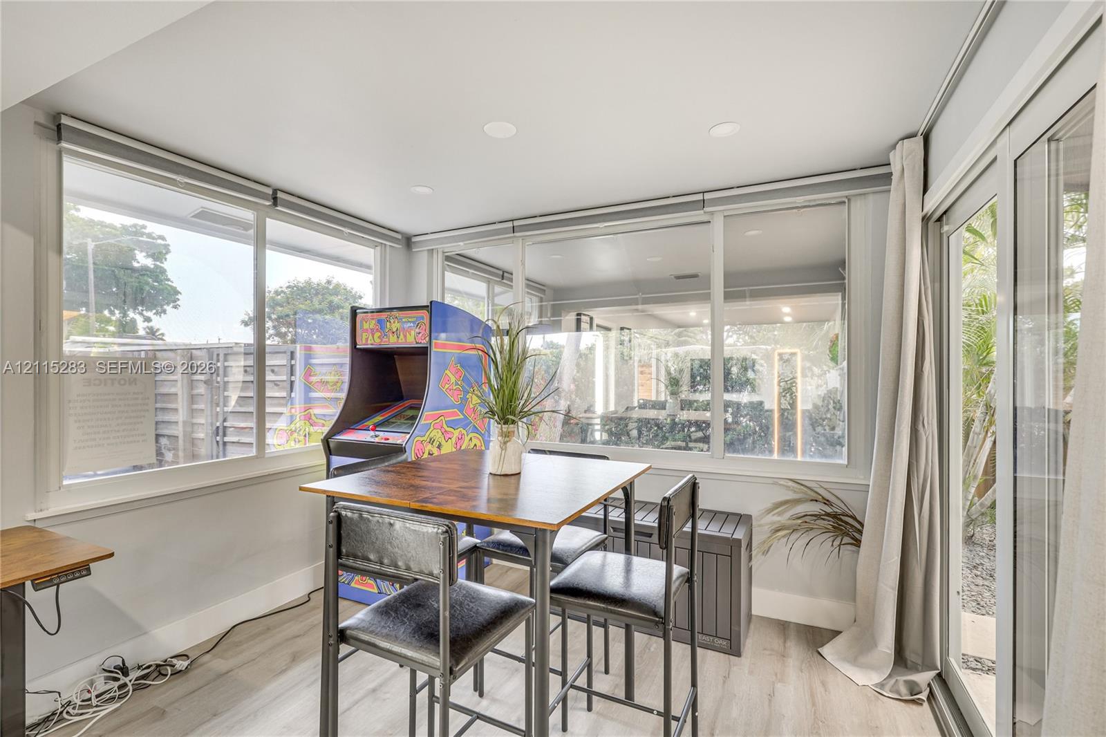 Sunroom featuring expansive windows, recessed lighting, and wood-finish flooring with sliding glass door access to the exterior