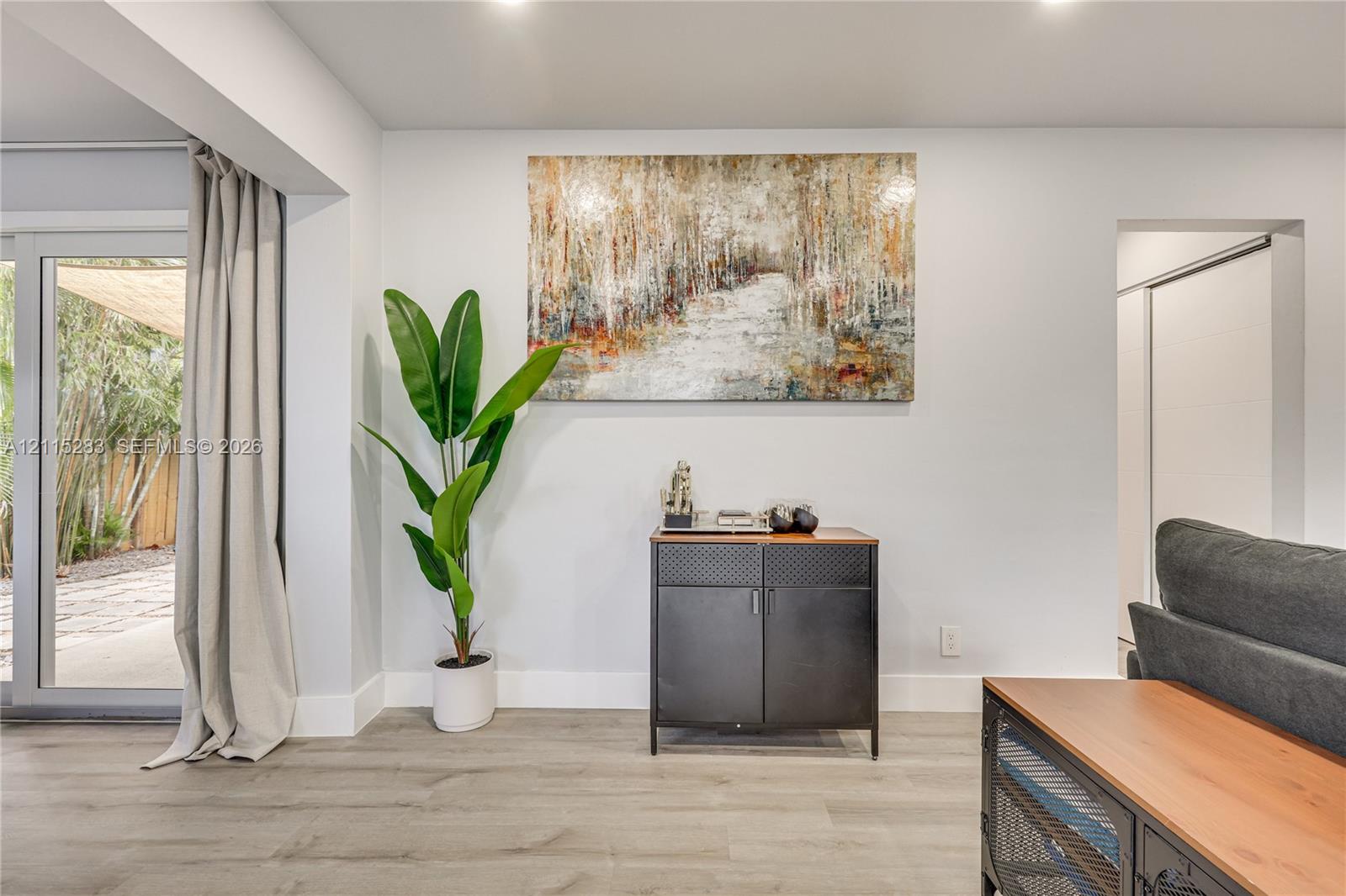 Neutral walls, wood-finish flooring, and recessed lighting, featuring sliding glass doors with outdoor access Neutral walls, wood-finish flooring, and recessed lighting, featuring sliding glass doors with outdoor access