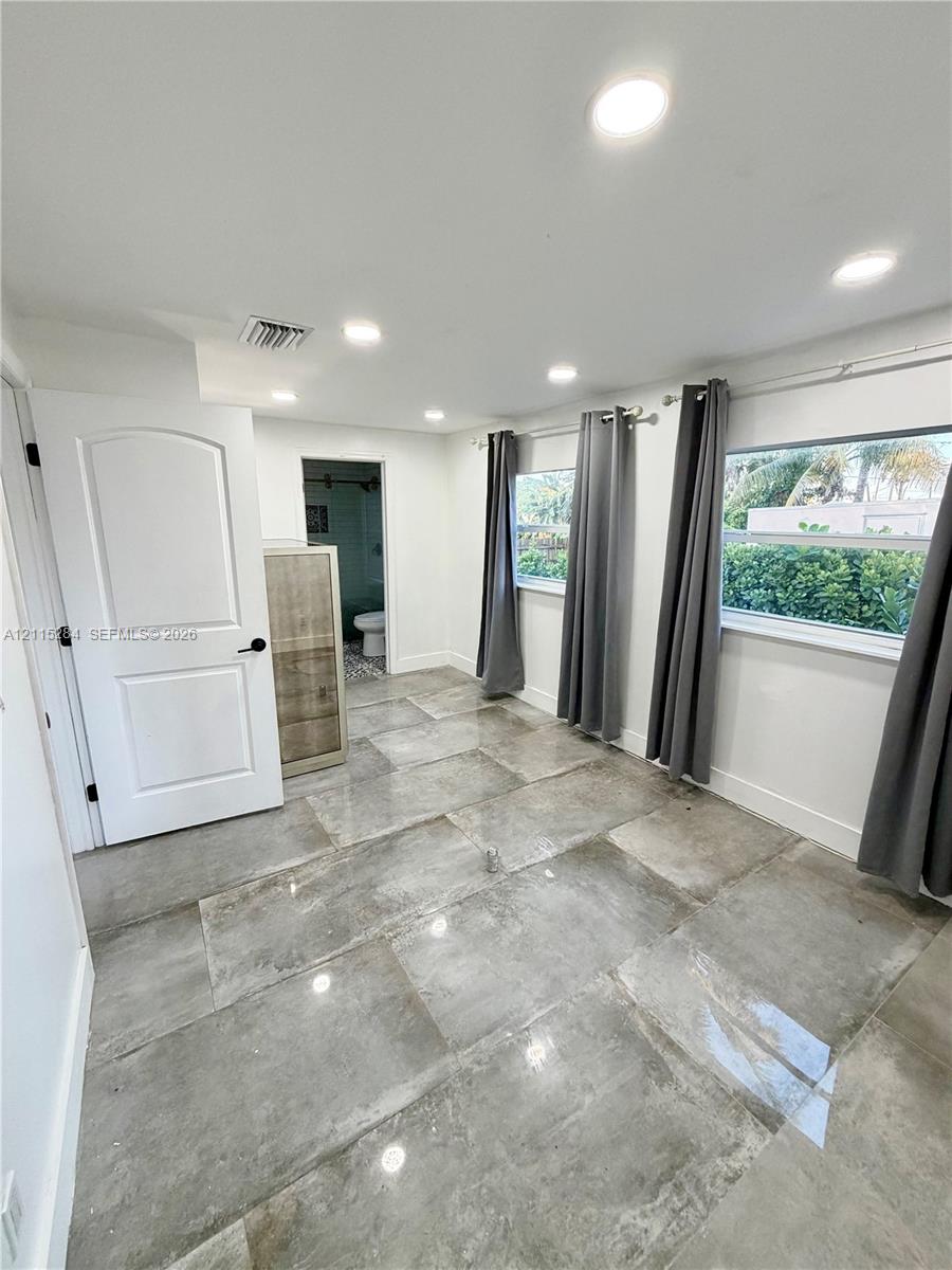 Large-format polished tile flooring, recessed ceiling lighting, and expansive windows featuring horizontal panes
