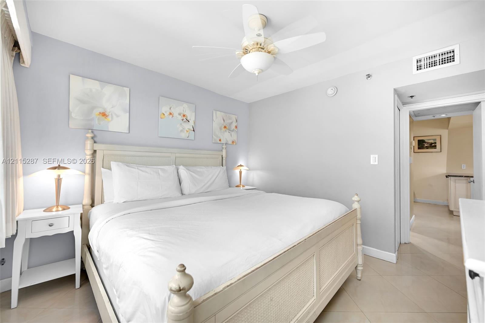 Neutral-toned walls paired with tile flooring, featuring a ceiling-mounted light fixture and fan combination