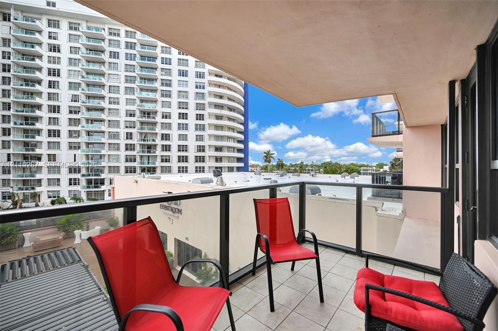 Covered balcony featuring tile flooring and a glass panel railing